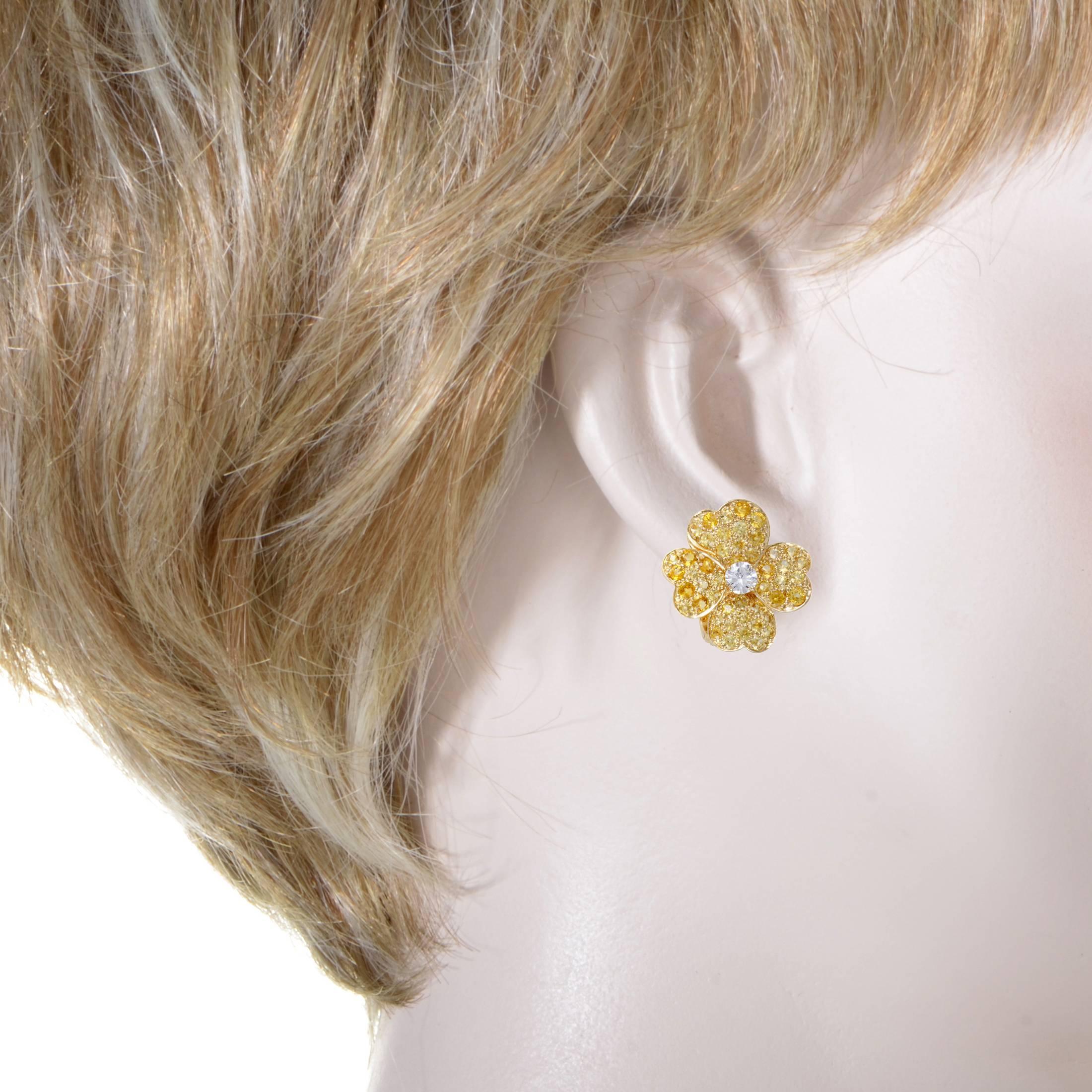 Presented within the sublime "Cosmos" collection, these splendid Van Cleef & Arpels earrings boast a gorgeously feminine appeal. The pair is made of attractive 18K yellow gold and lavishly set with diamonds and yellow