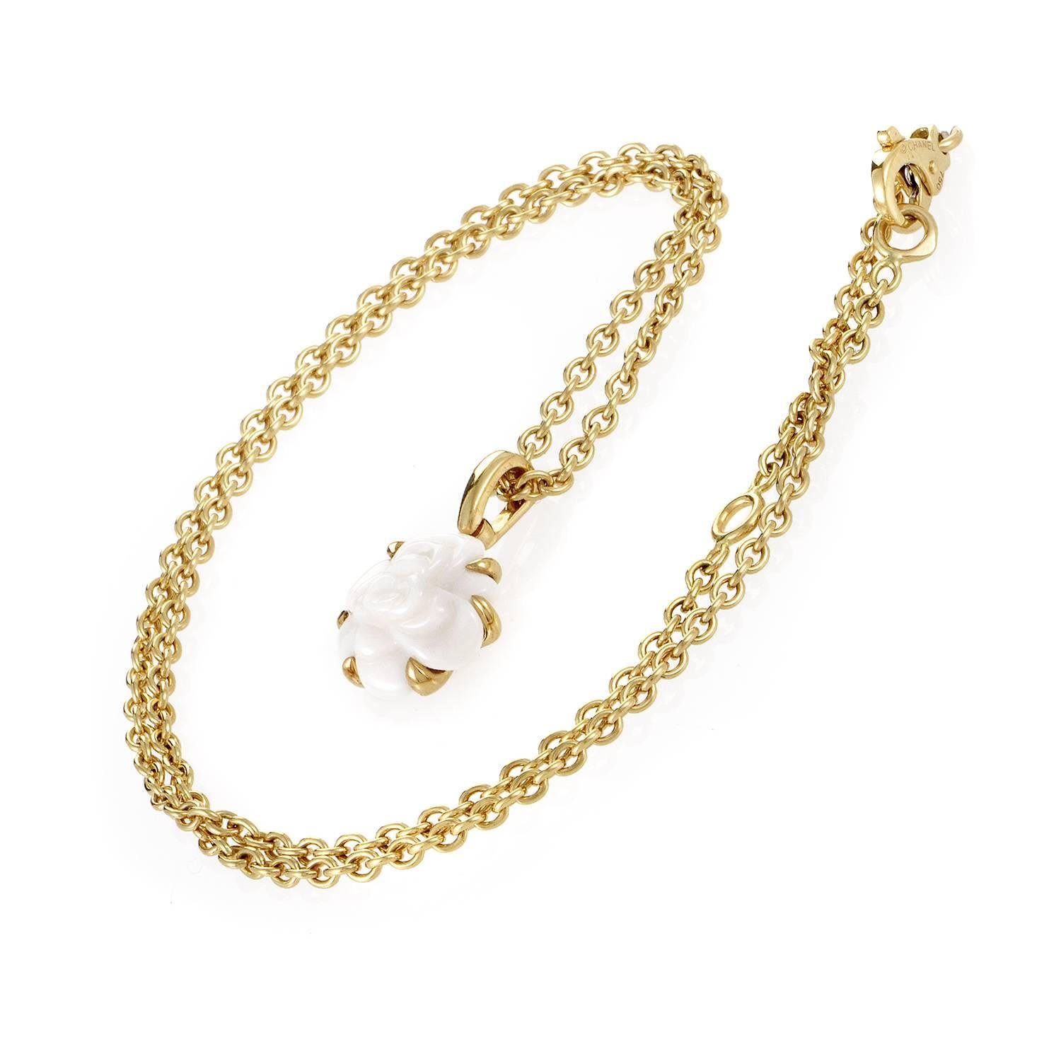 The familiar favored motif of the camélia flower is the focal point to this Chanel pendant. 18K yellow gold drops in fine links, narrowing in on a seamlessly shaped stone of white agate. The prefect plains of each petal roll as fluidly as tides