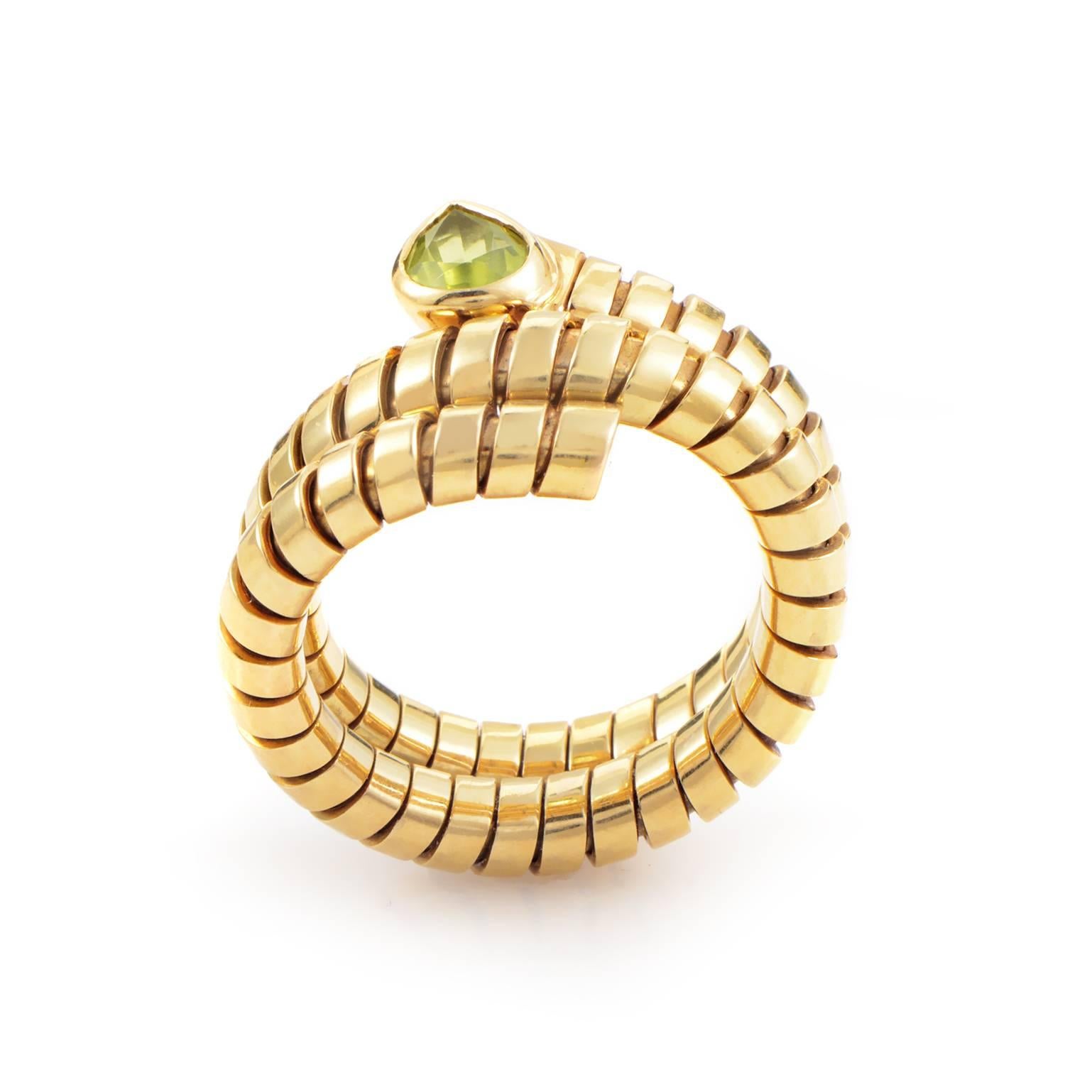 With serpentine sleekness this Tubogas ring wraps snugly three times in a glamorous grasp of 18K yellow gold. Leading this rivulet of precious slivers is the ripe setting of peridot that punctuates the ring's rippling curves. Compelling style and