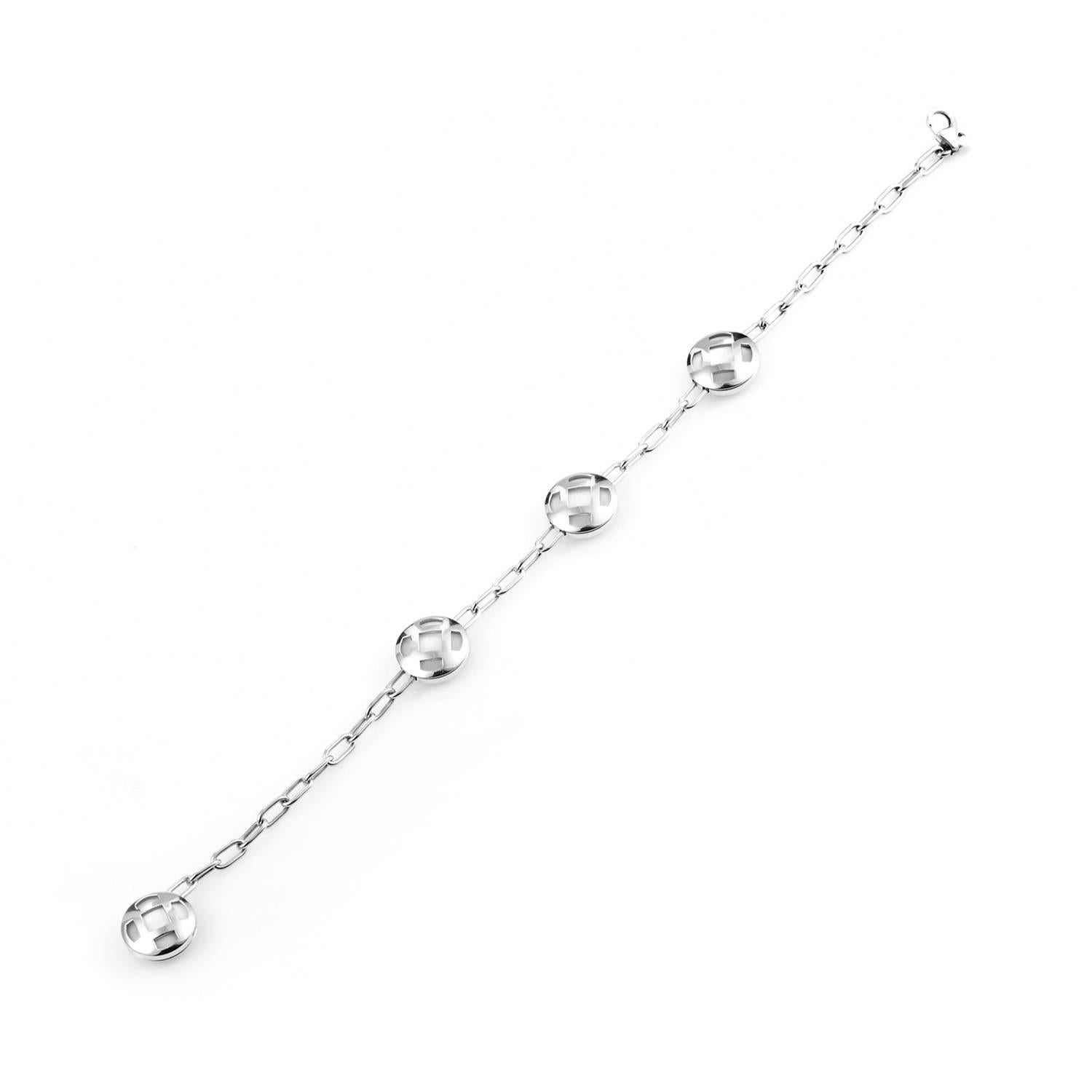 18K white gold is shaped into delicate links. The chain's flow periodically fans out into circular criss-cross housings, four in total, that frame the immaculate glow of mother of pearl. This is a loose bracelet that conforms readily to the wearer's