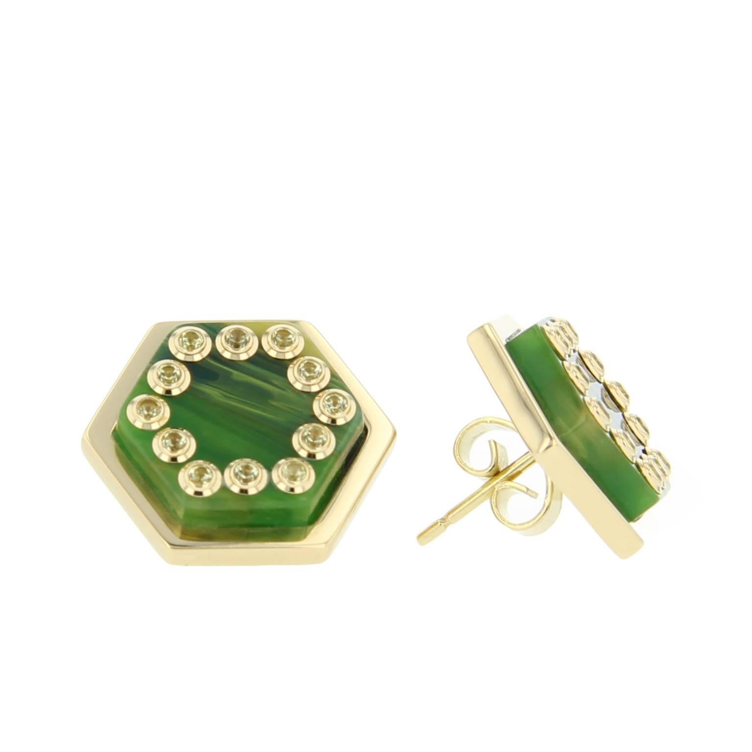 These hexagonal stud earrings were created using laminated, marbled blue and green  bakelite mounted in polished 18k yellow gold bezels. They are set with individual bezel-set peridot set in 18k yellow gold.

Full details below: 
• From of the Mark