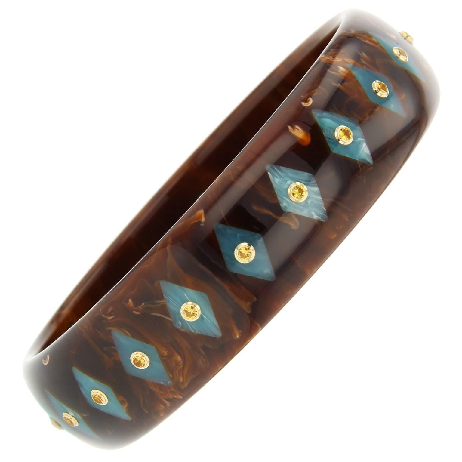 This Mark Davis Collector bangle was handcrafted using marbled brown and light blue  bakelite. Centered within the kite-shaped inlay pattern is a yellow sapphire set in 18k yellow gold.  

Full details below: 
• From the Mark Davis Collector line
•