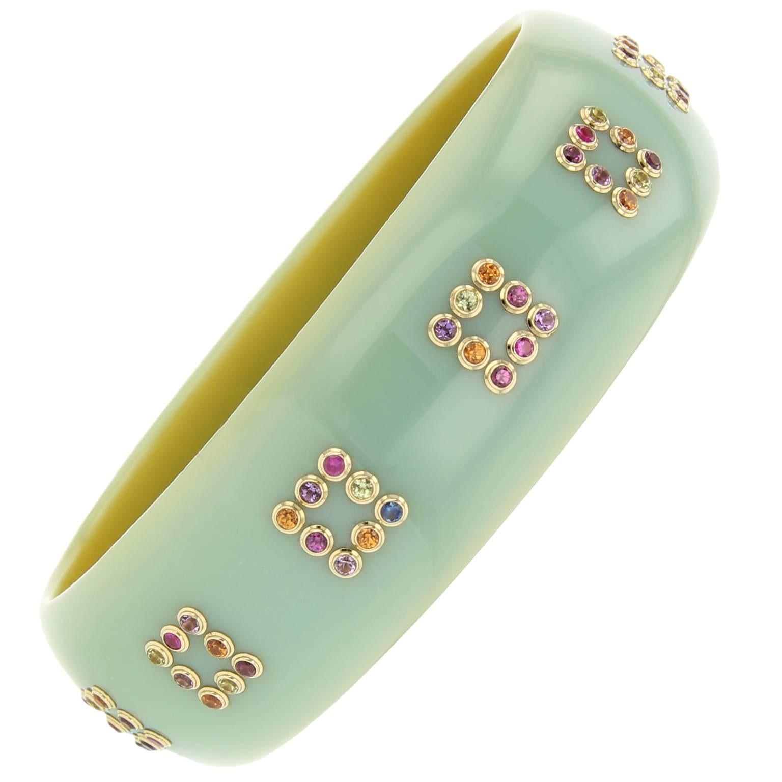 This Mark Davis bangle was handcrafted using unique bluish-green vintage bakelite. Amethyst, peridot, garnet and sapphire set in 18k yellow gold bezels create the square-shaped pattern that rings this truly one-of-a-kind piece.

Full details