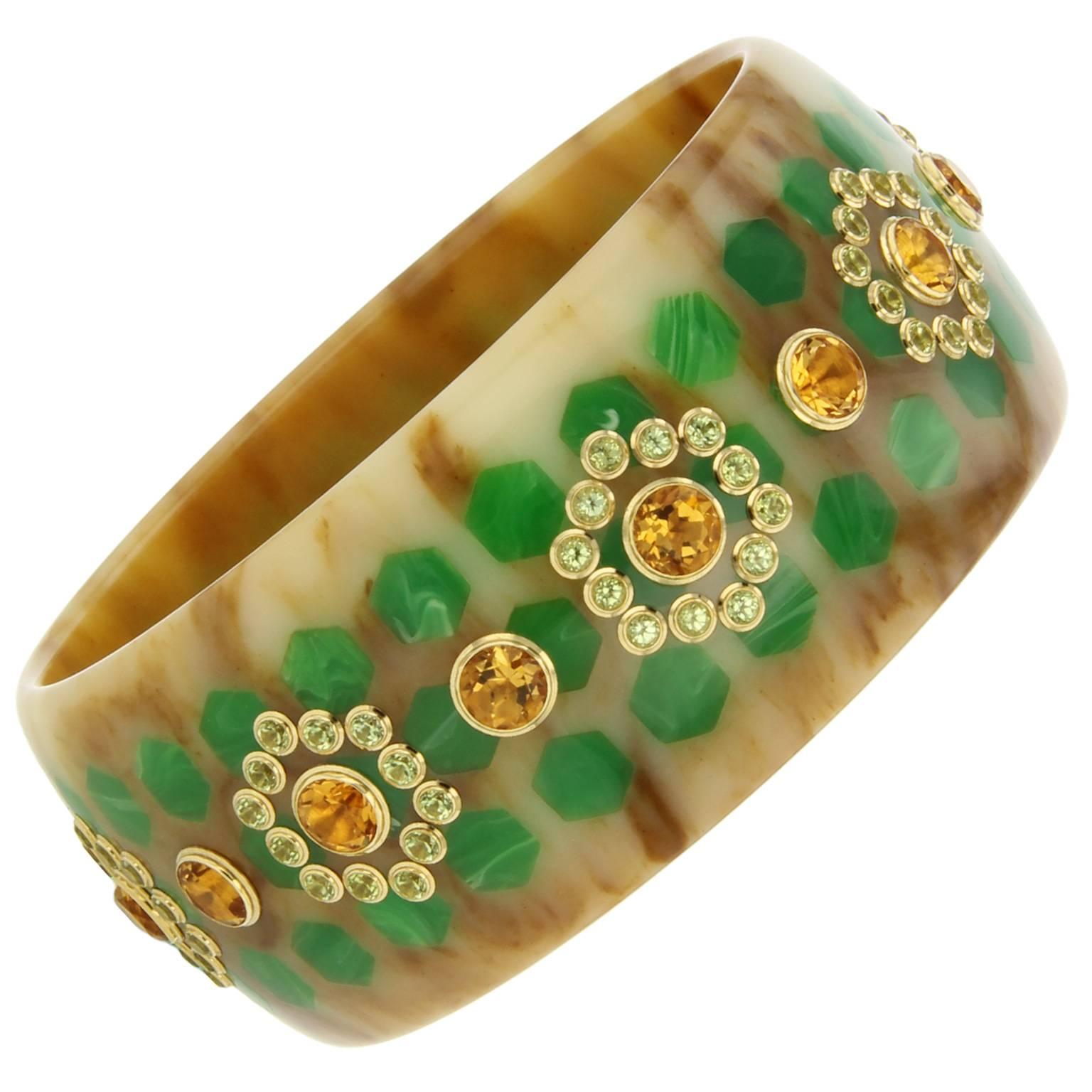 This is an eye-catching, marbled beige and green vintage bakelite bangle.  Masterfully inlaid with hexagonal shapes and studded with peridot and large round citrine set in 18k yellow gold bezels.   

Full details below: 
• From the Mark Davis