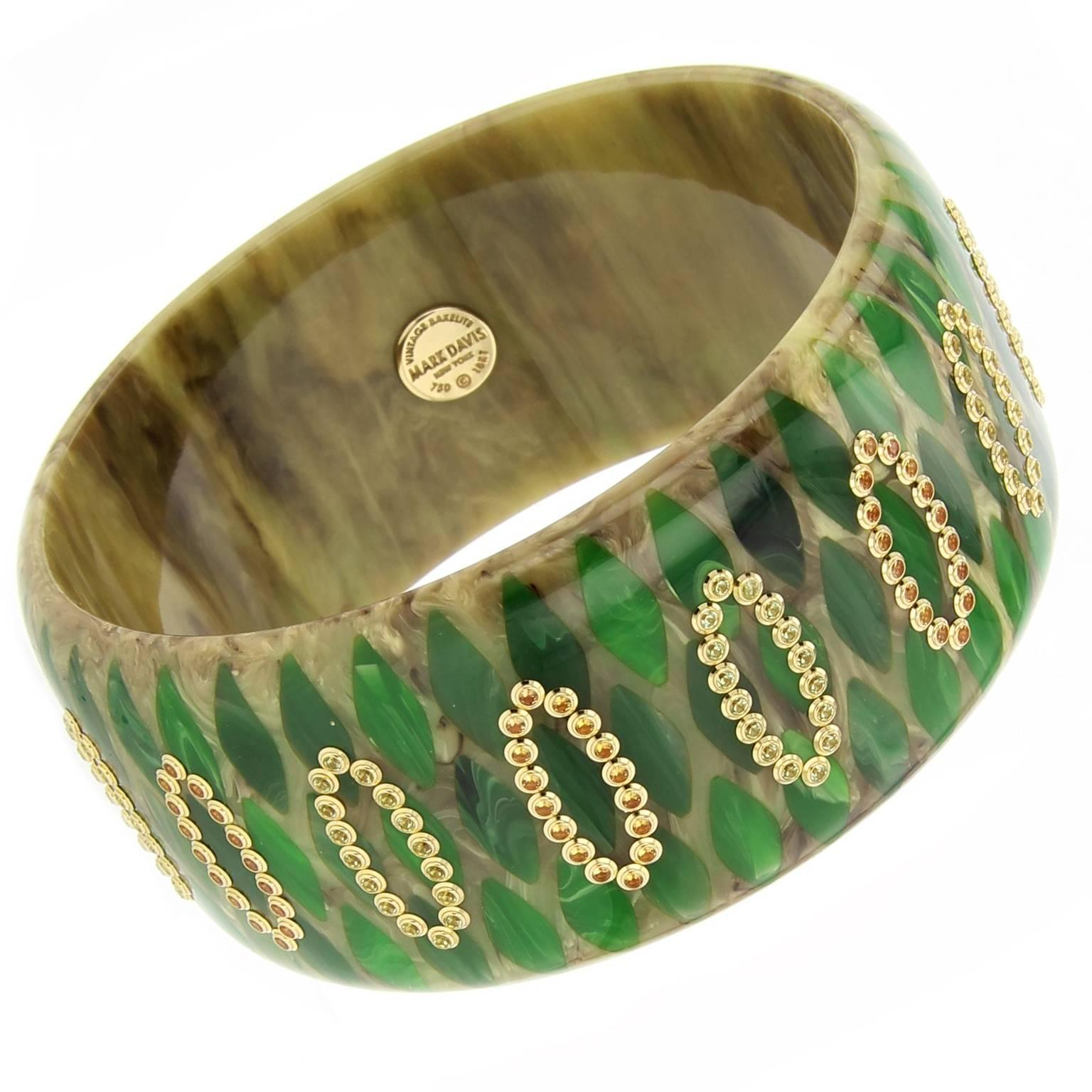 This exceptional Mark Davis Collector bangle was created from marbled beige and green vintage bakelite. The bangle is precisely inlaid with an elliptical pattern of forest green bakelite pieces. Fine yellow sapphire and peridot, bezel-set in 18k