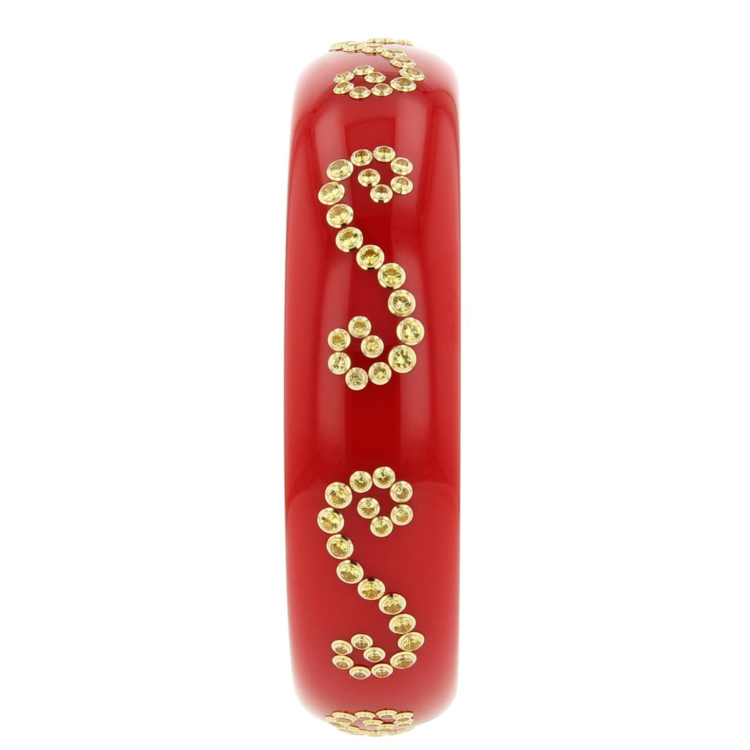 This impactful Mark Davis bangle was handcrafted using solid bright red vintage bakelite. It is decorated with fine yellow sapphires set in 18k yellow gold bezels creating an elegant scroll motif.

Full details below: 
• From the Mark Davis Bakelite