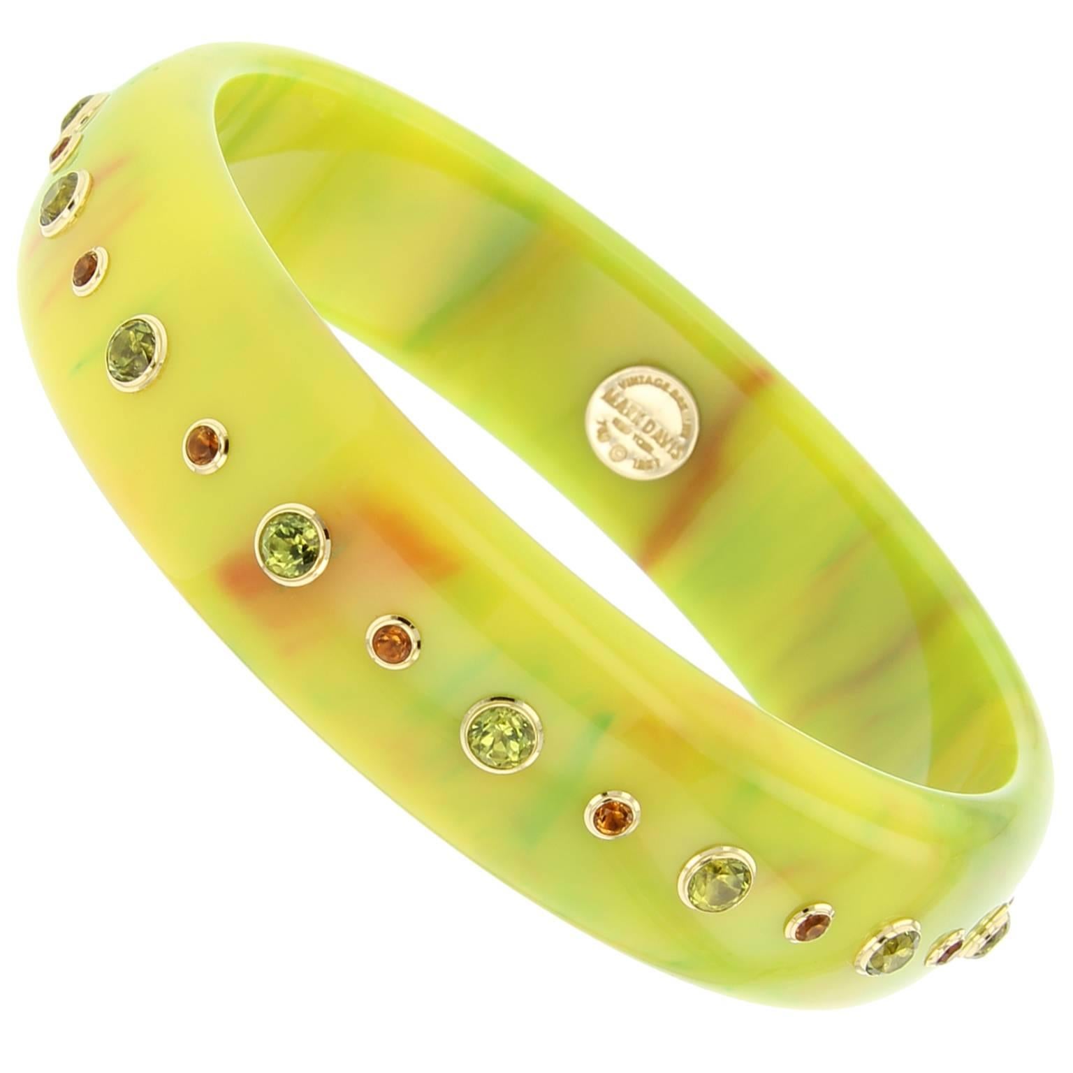 This Mark Davis bangle is handcrafted using a uniquely colored acid green and marbled orange vintage bakelite. Studded with citrine and peridot bezel-set in 18k yellow gold.  
 
Full details below: 
• From the Mark Davis Bakelite collection
•