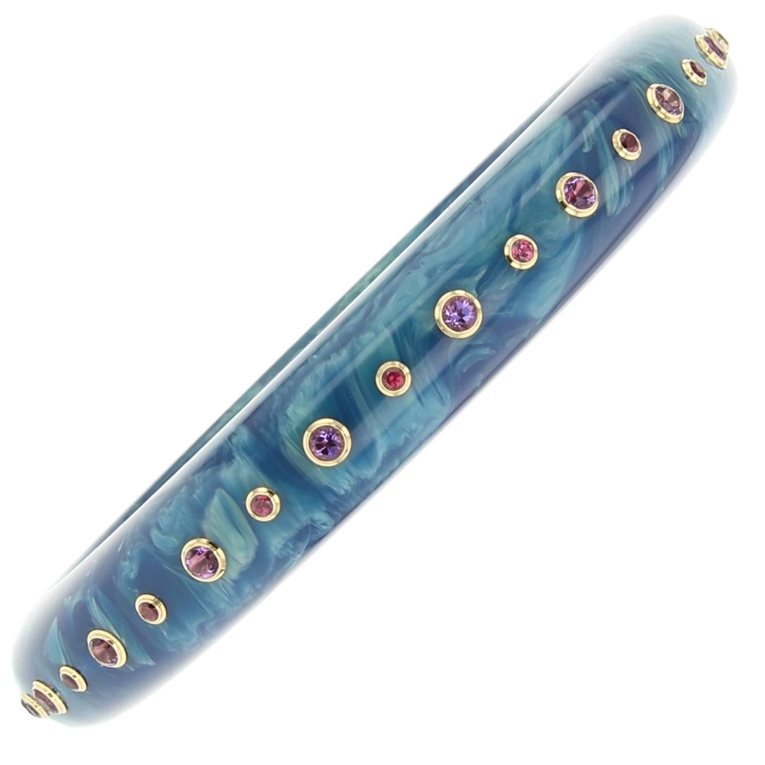 This bangle is part of the Mark Davis Bakelite Collection. It was handcrafted using marbled blue vintage bakelite and studded with amethyst and garnet bezel-set in 18k yellow gold.    

Full details below: 
• From the Mark Davis Bakelite Collection