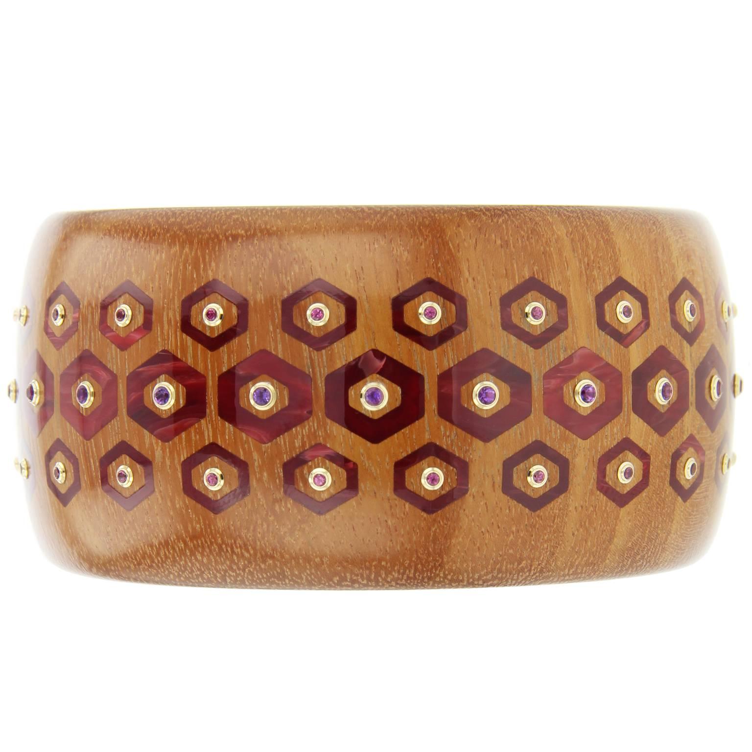 This classic Mark Davis bangle was handcrafted of tempisque wood and inlaid with hexagonal shaped pieces of burgundy bakelite.  At the center of each hexagon is an amethyst or rhodolite garnet, bezel-set in 18k yellow gold.  

Full details below: 
•