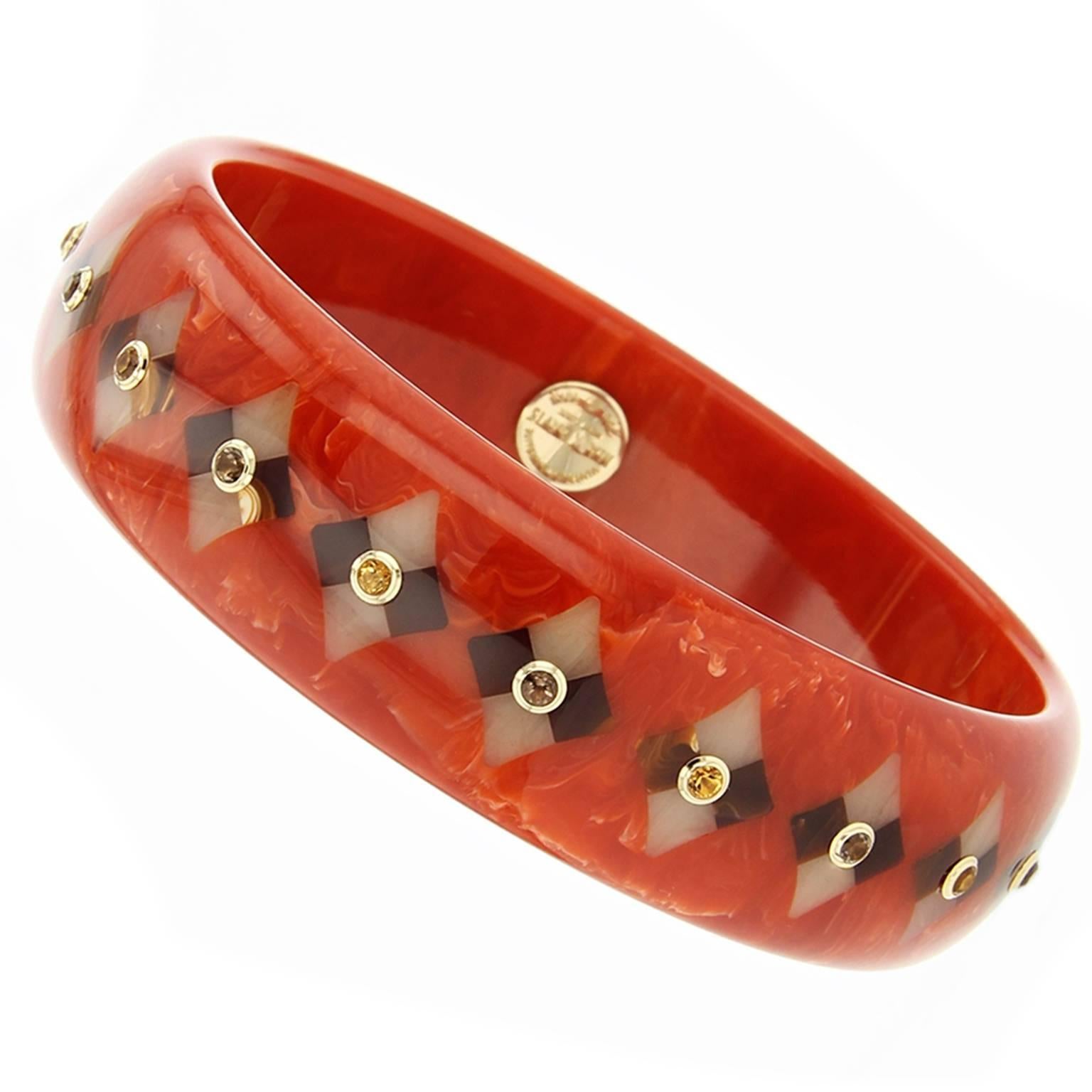 This Mark Davis Collector bangle was handcrafted of vintage marbled orange bakelite. The diamond-shaped mosaic pattern was precisely inlaid with pieces of brown and beige bakelite.  Each motif is centered with an alternating citrine or smoky quartz,