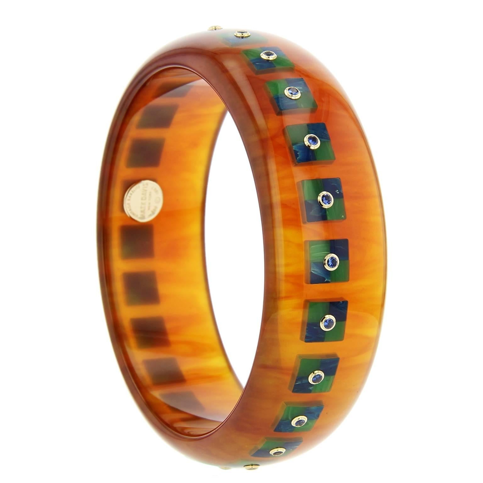 This sophisticated Mark Davis bangle was handcrafted using tortoise bakelite. The square-shaped mosaic pattern was precisely inlaid with pieces of blue and green bakelite.  Each motif is centered with a blue sapphire, bezel-set in 18k yellow gold.