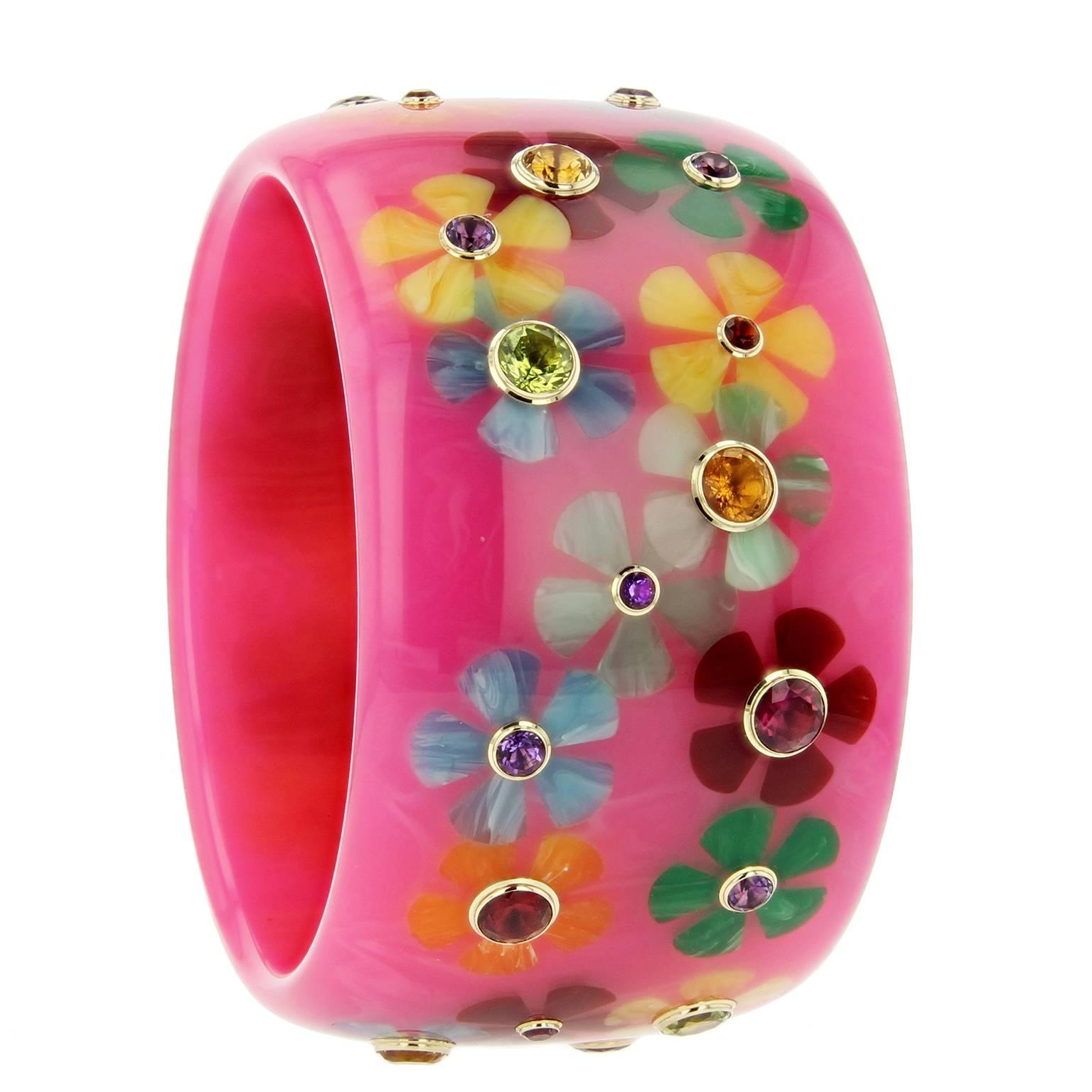 This delightful Mark Davis bangle was handcrafted of pink vintage bakelite.  The flower motif was intricately inlaid with multi-colored pieces of bakelite.  Each flower is centered with a amethyst, garnet, peridot, citrine, or sapphire bezel-set in