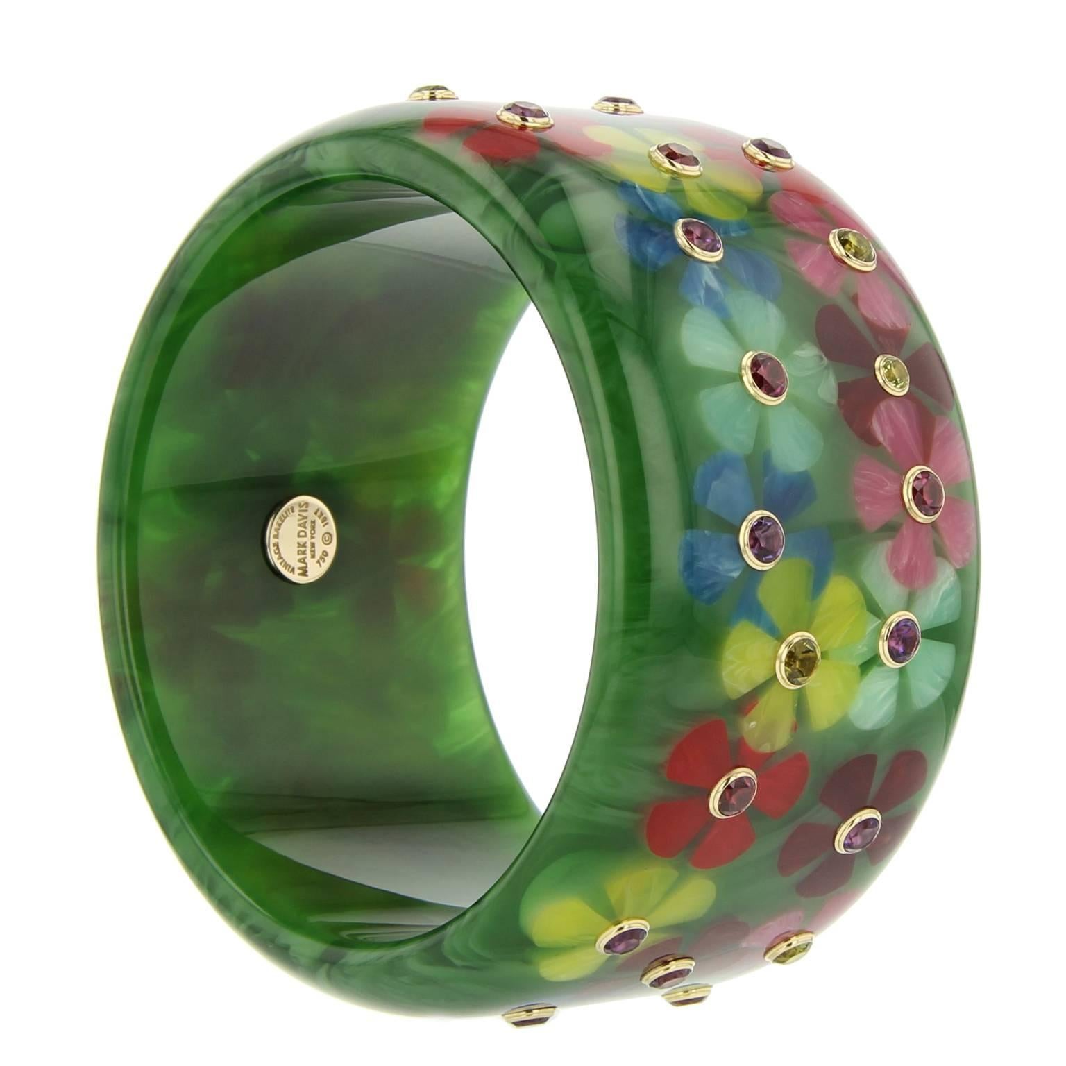 This statement Mark Davis bangle was handcrafted of green vintage bakelite.  The flower motif was intricately inlaid with multi-colored pieces of bakelite.  Each flower is centered with a amethyst, rhodolite garnet, or peridot bezel-set in 18k