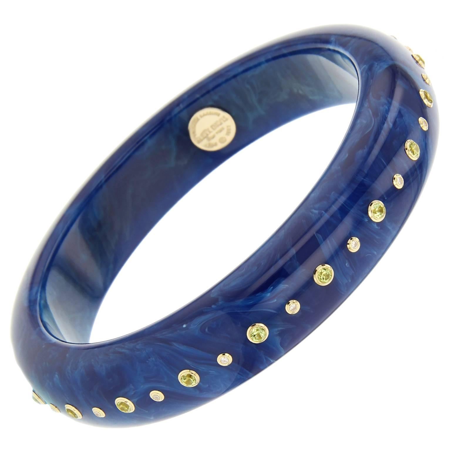 This chic Mark Davis bangle was handcrafted using marbled blue vintage bakelite and studded with peridot and fine diamonds, bezel-set in 18k yellow gold.    

Full details below: 
• From the Mark Davis Bakelite Collection 
• Vintage marbled blue