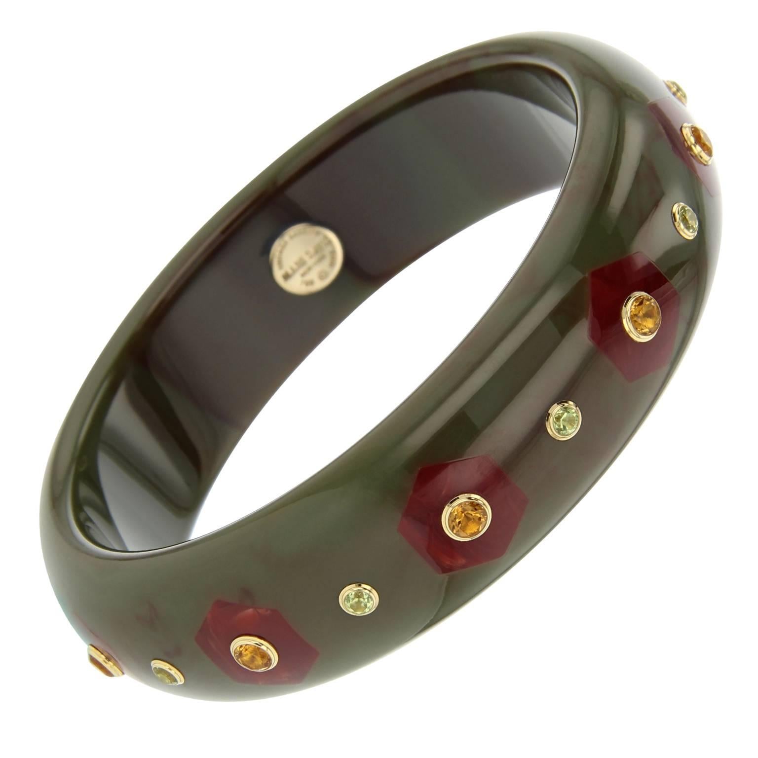 This Mark Davis bangle was handcrafted using olive green vintage bakelite and meticulously inlayed with hexagonal shaped pieces of burgundy bakelite. Each hexagon is centered with a citrine and in between is a peridot, bezel-set in 18k yellow gold.
