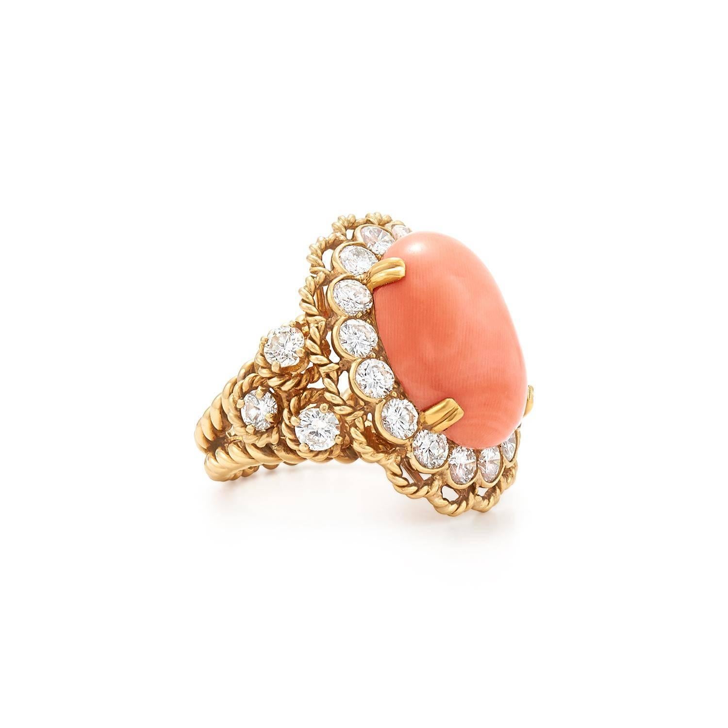 Set with a cabochon coral within a round brilliant diamond surround flanked to either side by three round brilliant diamonds to the 18k gold twisted rope shank and detail, mounted in 18k gold

Coral Cabochon measures approximately 19.0 by