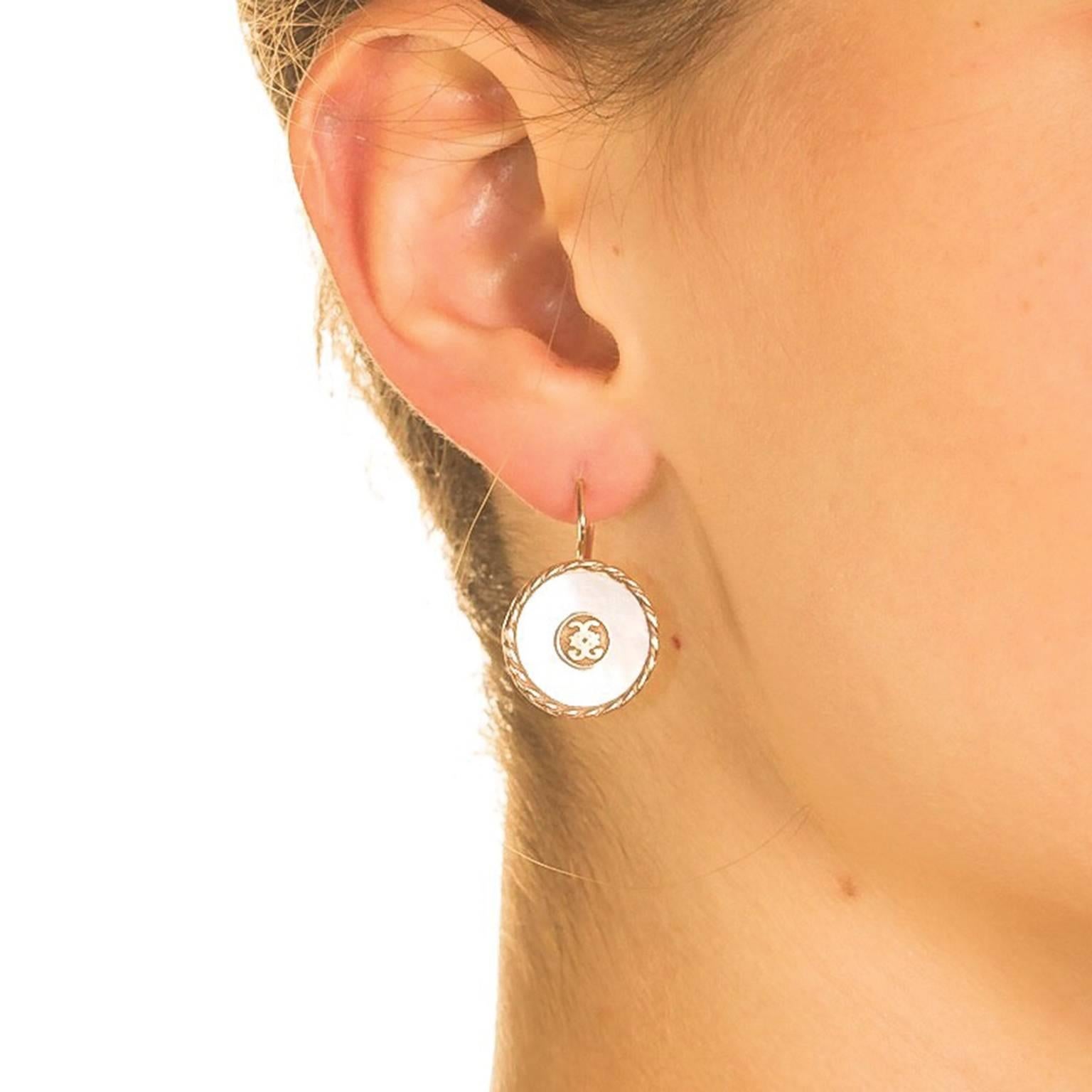 Classic and classy, these graceful earrings are the embodiment of simple elegance.  A ‘CdG’ coat of arms is engraved in 18 karat yellow gold vermeil and set in a shimmering white pool of mother of pearl.  This sophisticated composition is completed