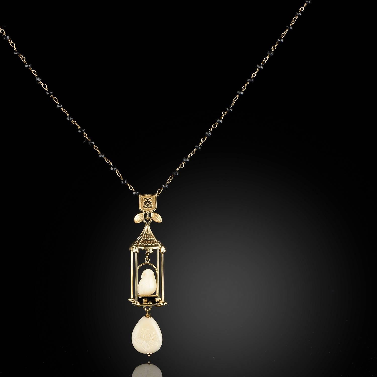 Vermeil and onyx link to make this distinctive necklace. The piece is capped by a pure white bird perched in a gilded cage hanging below a CdG shield. 

The carved material which resembles ivory in our jewelry is Nuvory™, the nut of the South
