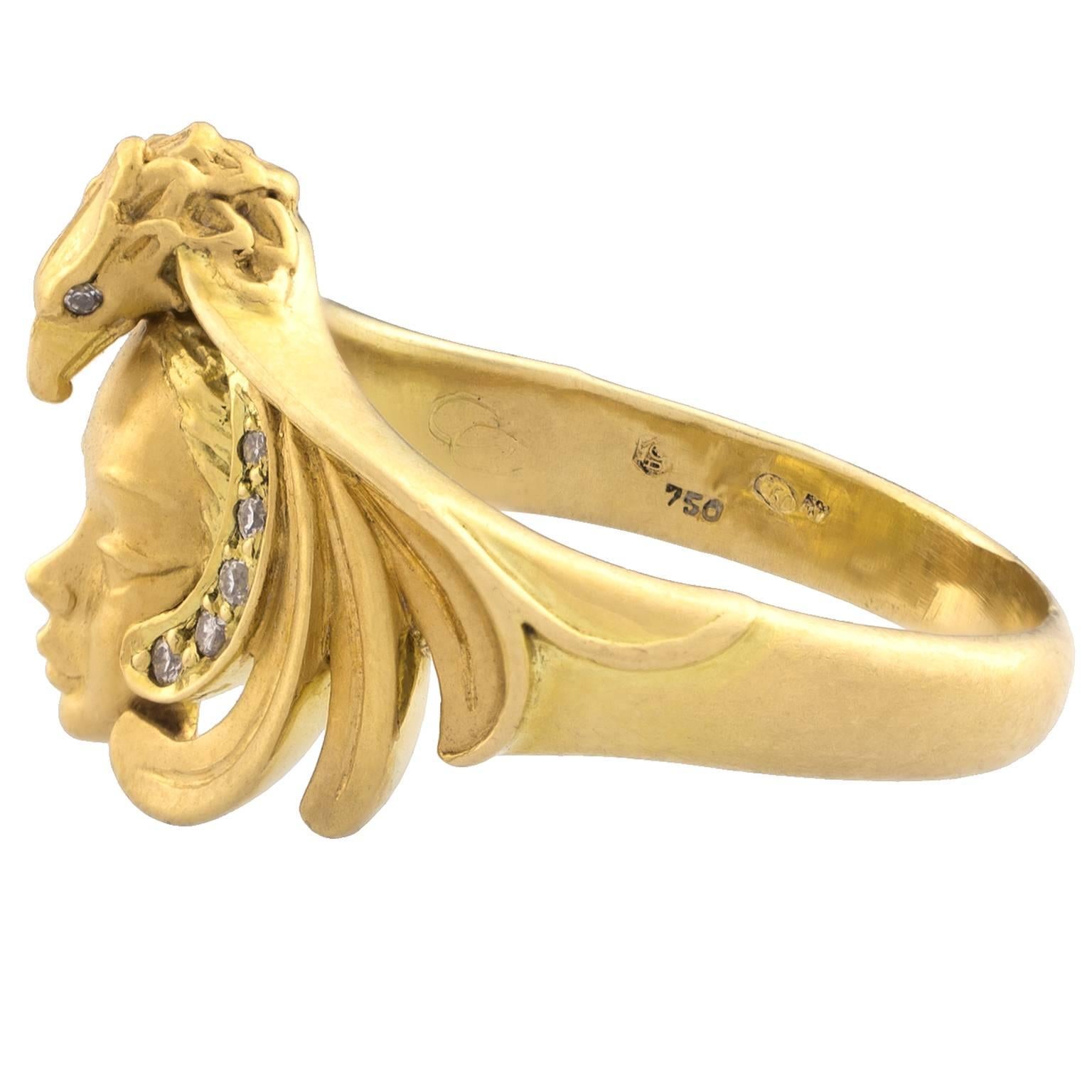 Carrera y Carrera ring in gold with a central motif of a woman's face encompassed by a wing-spread eagle set with 12 brilliant cut diamonds totalling 0.10 carats.
Size: Swiss 17, French 57, US 8