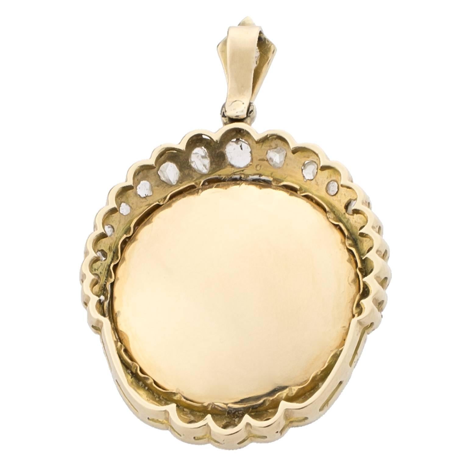 Early 20th century platinum-topped gold pendant with religious image in mother of pearl, surrounded by 0.10 carats in rose cut diamonds.
Dimensions: 21 x 19 mm (0.83 x 0.75 in) with a 7 mm (0.28 in) bale
