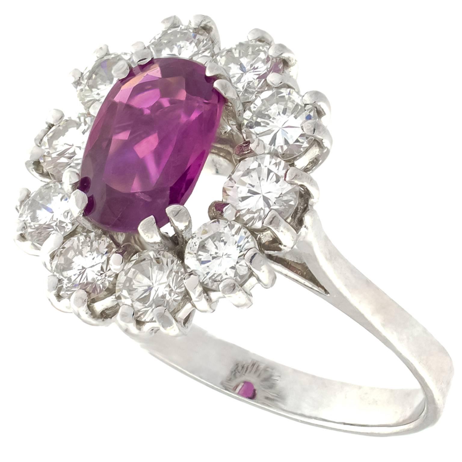 White gold ring centered by an oval cut pink sapphire with a weight of 0.75 carats, surrounded by 10 round brilliant cut diamonds, totalling 1.50 carats.
Size:  Swiss 13, French 53, US 6 1/2
Can besized