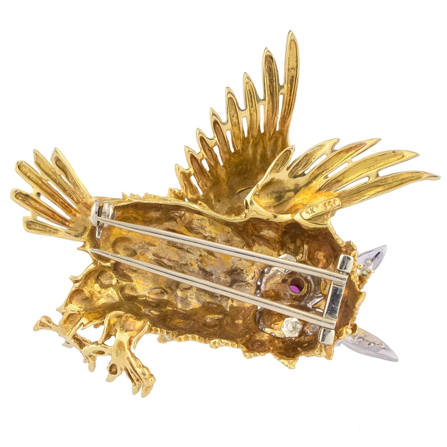 1970's brooch in plain and matte gold, both yellow and white, in the shape of an owl, decorated with 24 single cut diamonds, totalling 0.33 carats, rubies and enamel.
Dimensions: 55 x 50 mm (2.17 x 1.97 in)
