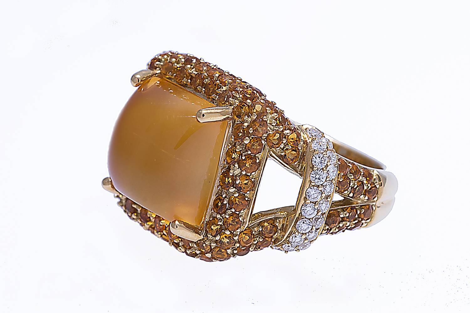 18K ring with a citrine cabochon weighing 9.19 carats in the center. The mounting contains yellow sapphires and diamonds. Size 7. Can be sized.