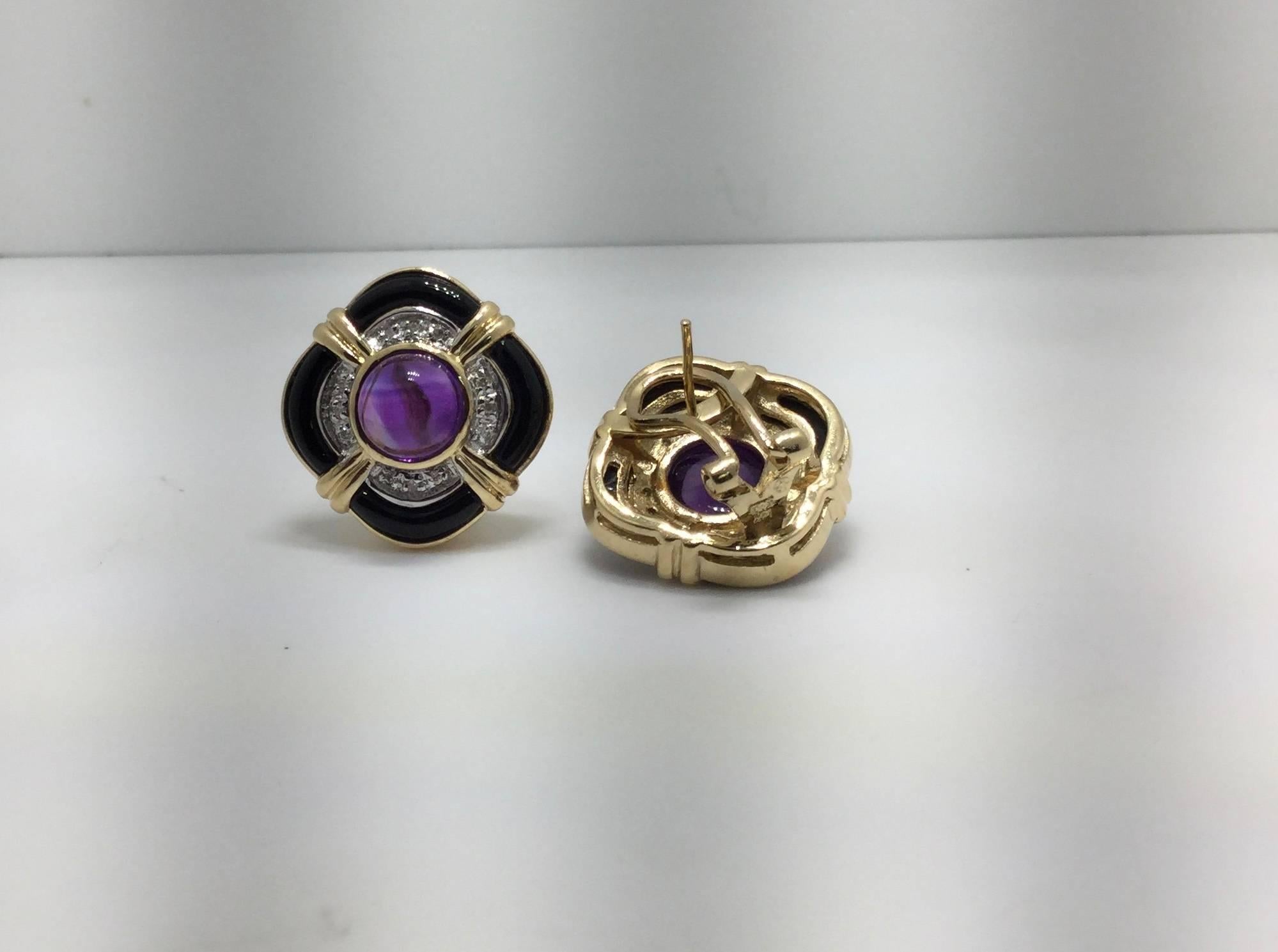 Earrings contain a round amethyst cabochon in the center surrounded by pave set diamonds and black onyx.  The amethyst is 7.8 mm in diameter and the diamonds weigh combined 0.19 carat. The earring have a diameter of 20x20mm.