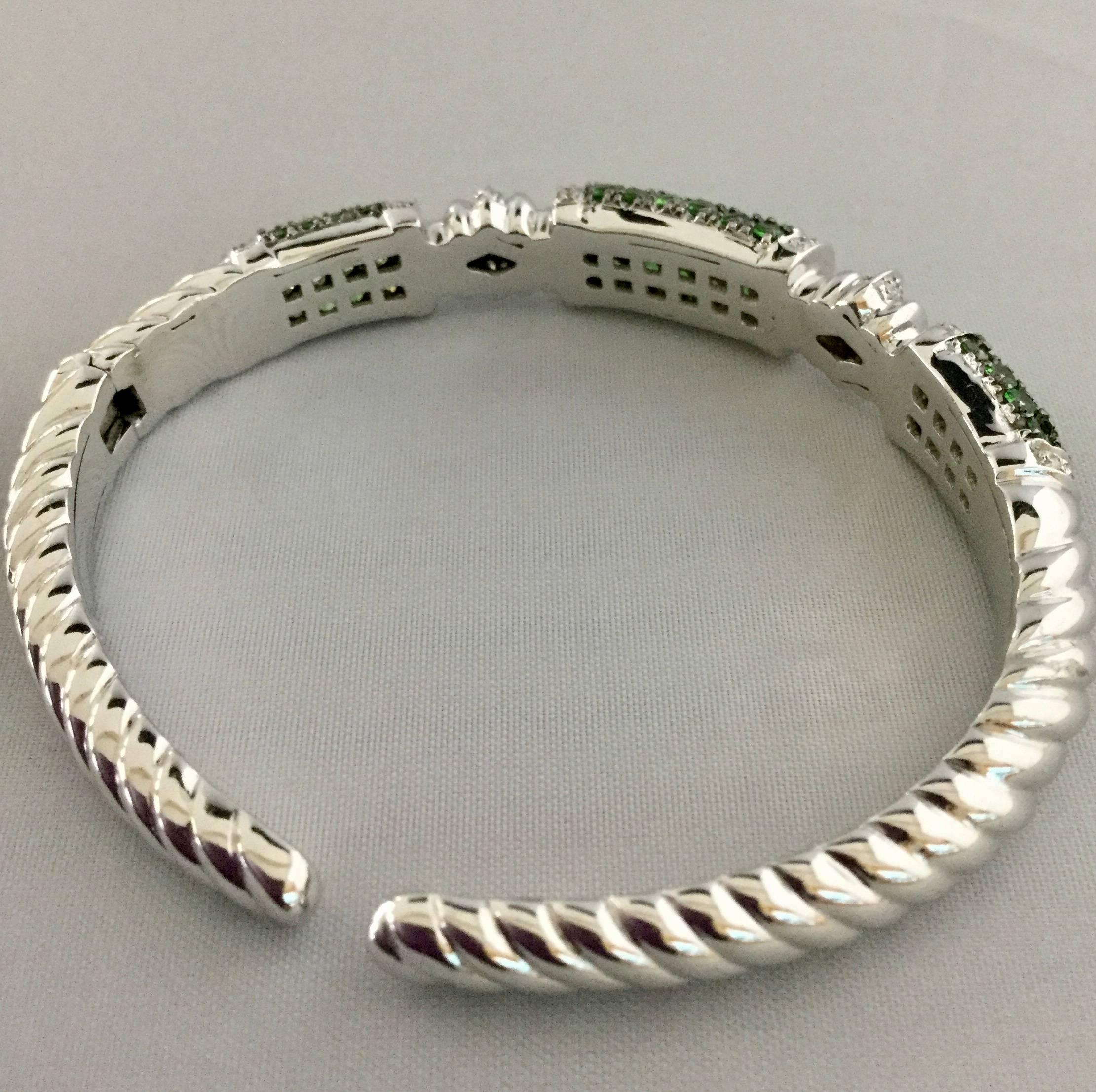 18K white gold hinged cuff bracelet with tsavorite and diamonds.The bracelet contains 56 tsavorite garnets weighing combined 3.30 carats and 58 diamonds weighing combined 0.58 carat.