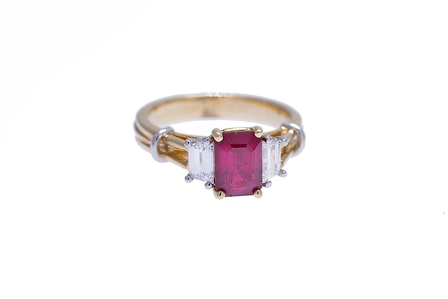 18K and platinum ruby and diamond ring containing one emerald cut ruby weighing 1.50 carats and two trapeze cut diamonds weighing combined 0.43 carat. Diamonds are F/VS1. This ring was designed and made in house with stones handpicked by our