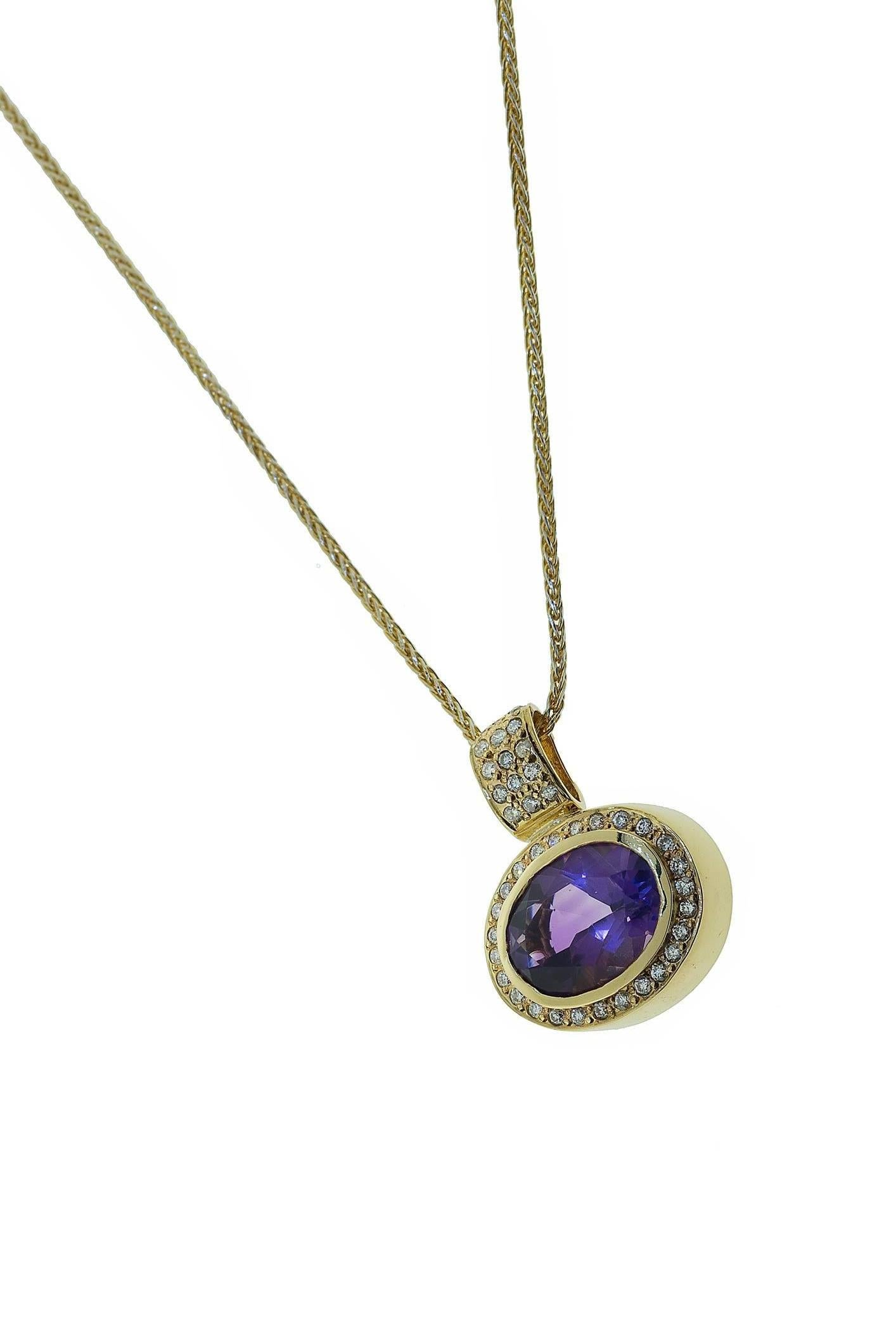 18K yellow gold oval amethyst and diamond pendant necklace. The 6.00 carat oval faceted amethyst is bezel set and surrounded by pave set diamonds. The bail is also set with pave set diamond. The diamonds weigh combined 0.41 carat. The pendant hangs