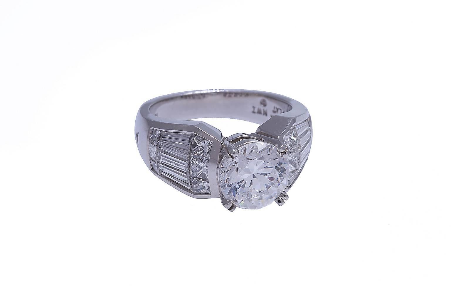 Platinum Nova ring with GIA certified 1.74 carats round brilliant cut diamond, H color, SI1 clarity.
The Nova mounting contains contains 23 diamonds, princess cut and baguettes, weighing combined 1.59 carats.
Mounting can be purchased without center