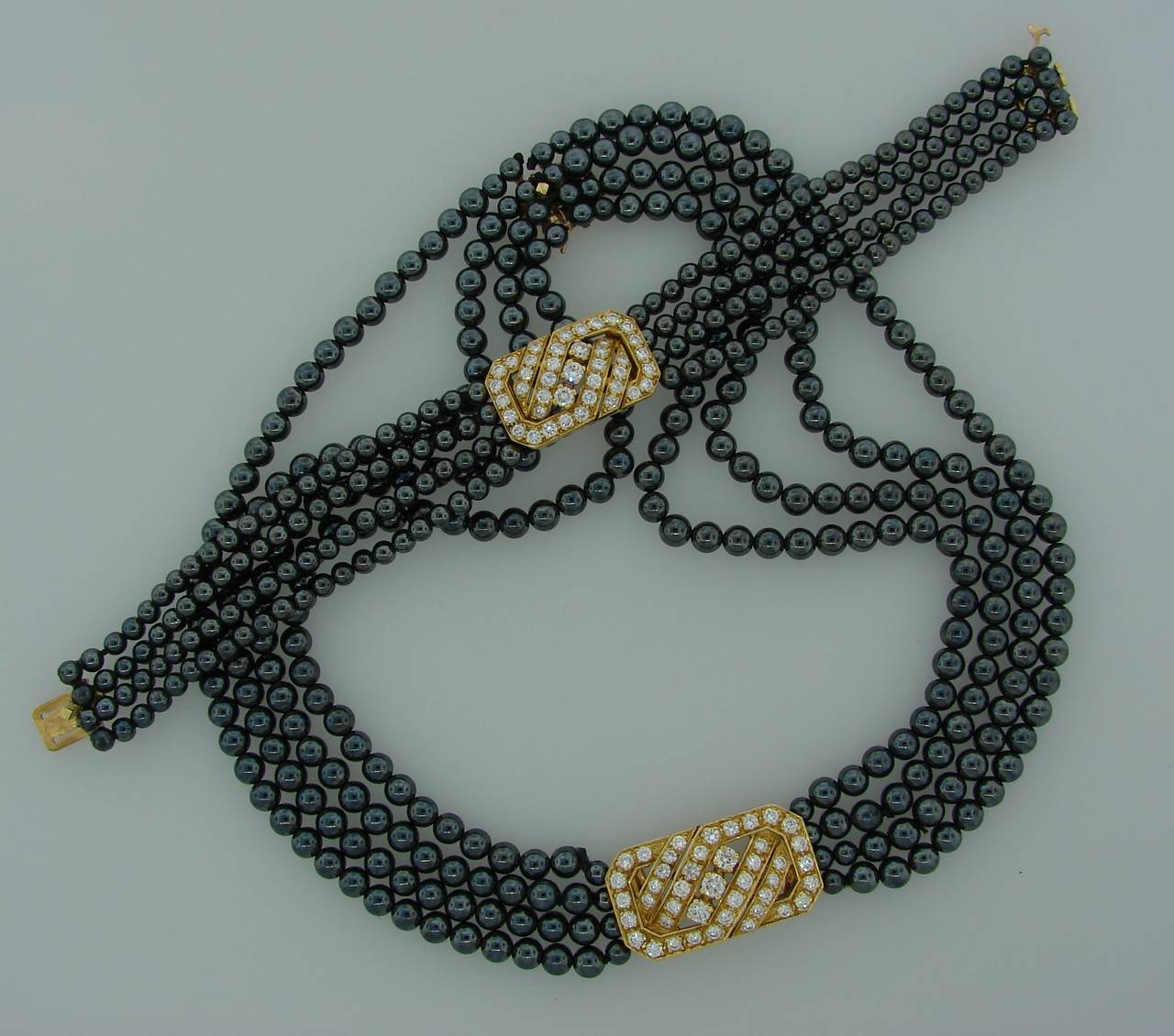 Elegant  and stylish necklace created by Van Cleef & Arpels in France in the 1970's. Features four strands of hematite beads connected with a beautiful diamond & yellow gold clasp. Versatile - can be worn as a longer necklace which gives