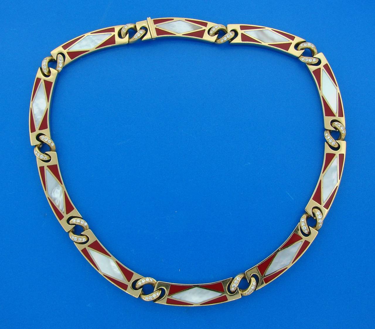 Rare necklace created by Bulgari in the 1970s. Features ten solid 18k yellow gold links inlaid with mother-of-pearl and red enamel. This links are connected with yellow gold and diamond links. 
Beautiful, colorful and very elegant. 
The necklace