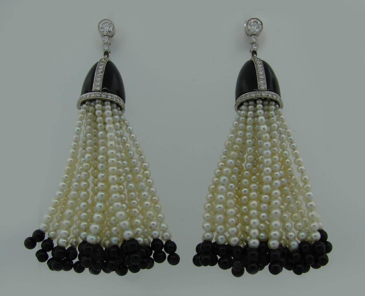 Chic and feminine tassel earrings created by Tiffany & Co. in the 1960's. Feature seed pearls, black onyx and round brilliant cut diamonds set in platinum. Diamond total weight is approximately 1.50 carats.
The earrings are 2.5" long