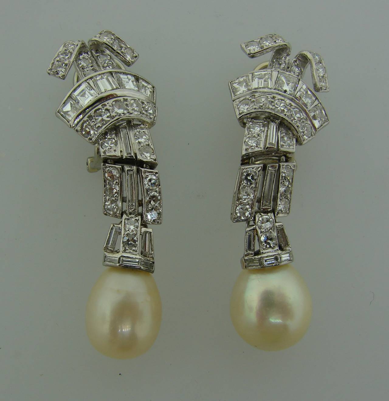 Elegant and classy earrings featuring two natural saltwater pearls set in platinum encrusted with diamonds.

The pearls are accompanied with a Gem Testing Report from French Gemological Laboratory stating that the pearls natural saltwater, total