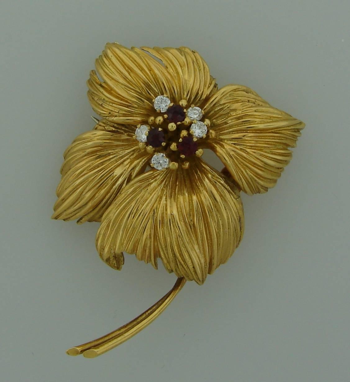 Lovely flower pin created by Van Cleef & Arpels in France in the 1950's. Made of 18k (stamped) yellow gold and accented with five round diamonds and three round rubies. Diamond total weight is approximately 0.35 carat and ruby total weight is