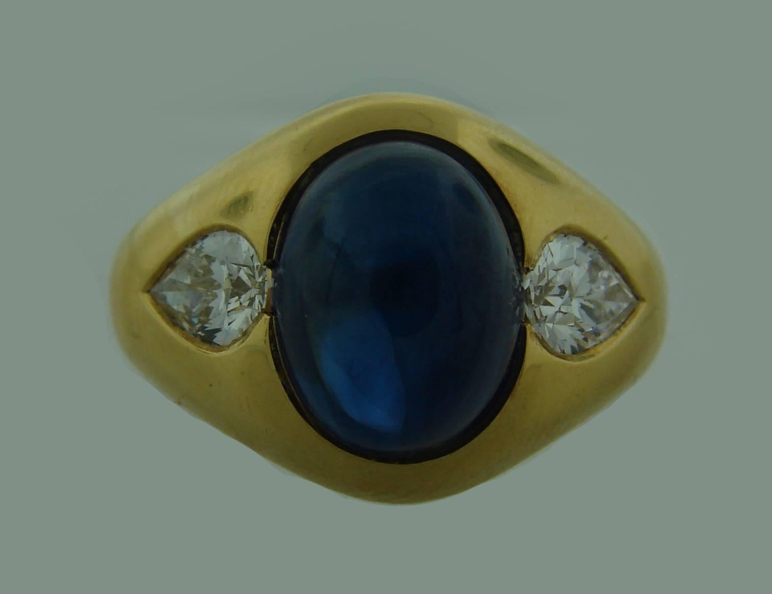 Classy and timeless cocktail ring created by Bulgari in the 1970's. Features 6.05-carat cabochon  sapphire set in 18k (stamped) yellow gold and accented with pear shape diamonds. The diamond total weight is approximately 1.04 carats, they are F-G