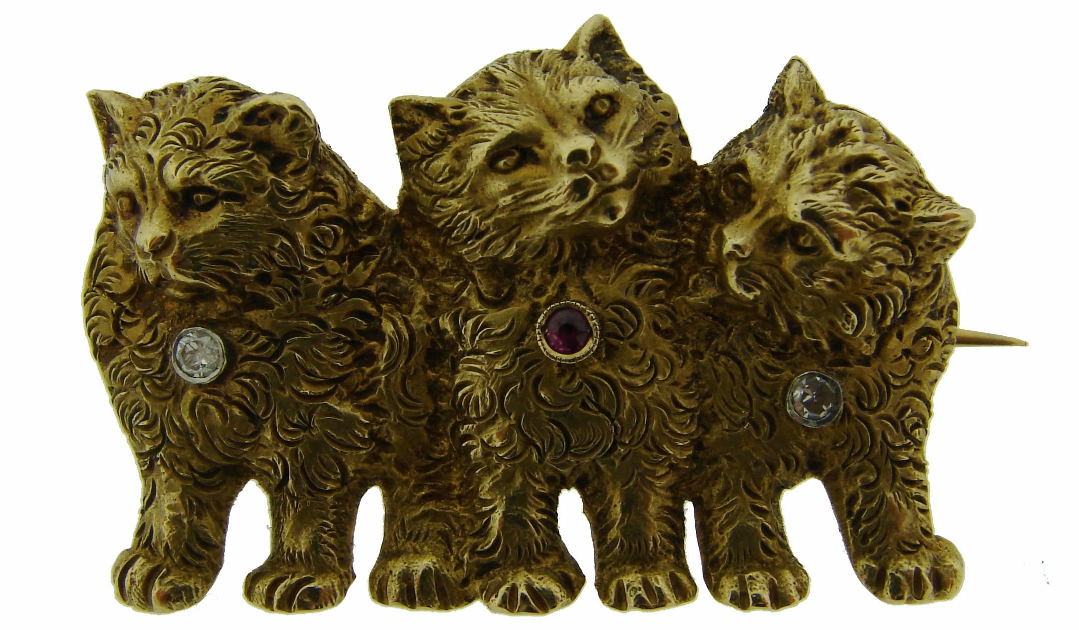 Cutest three-cats pin created in the 1900's. Made of 18k (stamped) yellow gold and accented with two diamonds and a ruby. 
The pin is 1.25