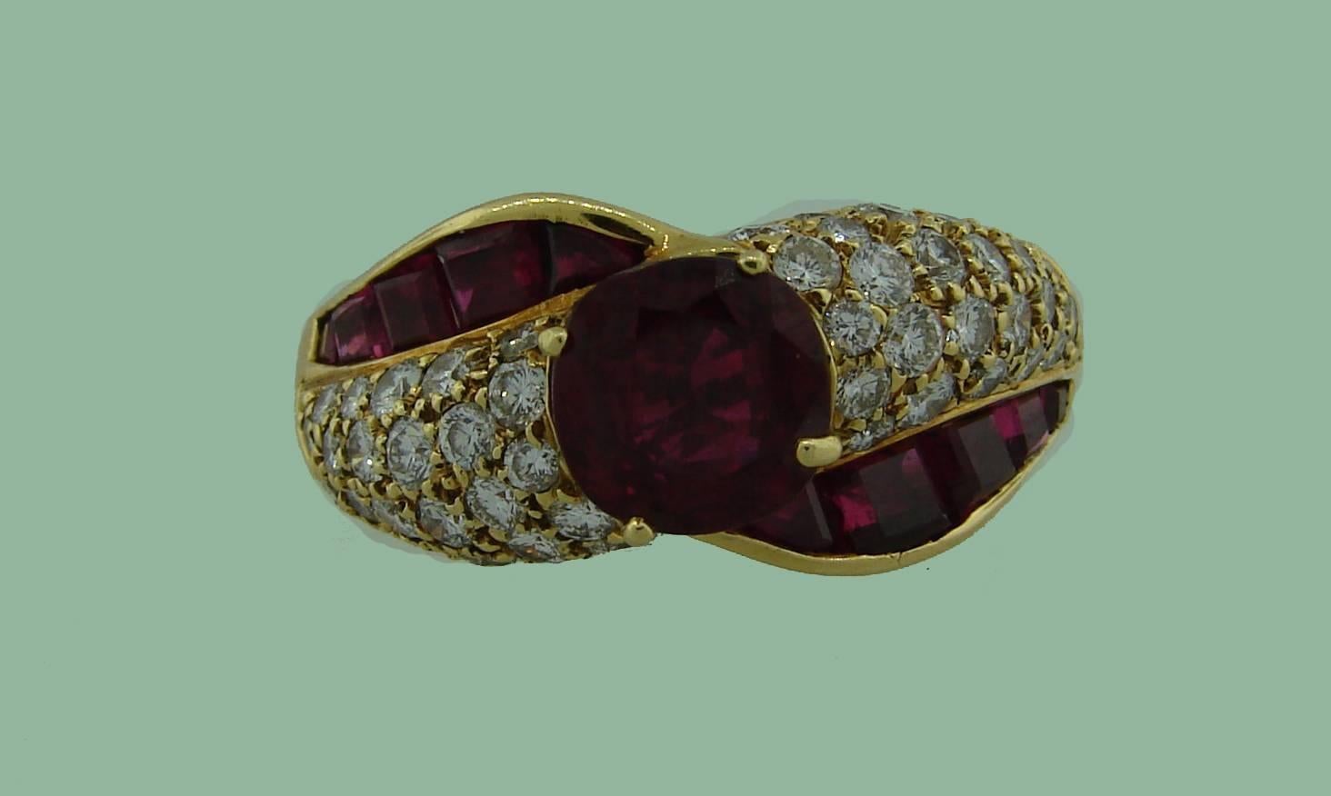 Chic and timeless cocktail ring created by GRAFF in the 1980's. Features an approximately 2.06 carat round faceted ruby accented with rubies and diamonds set in 18k yellow gold. The center ruby is accompanied with an American Gemological
