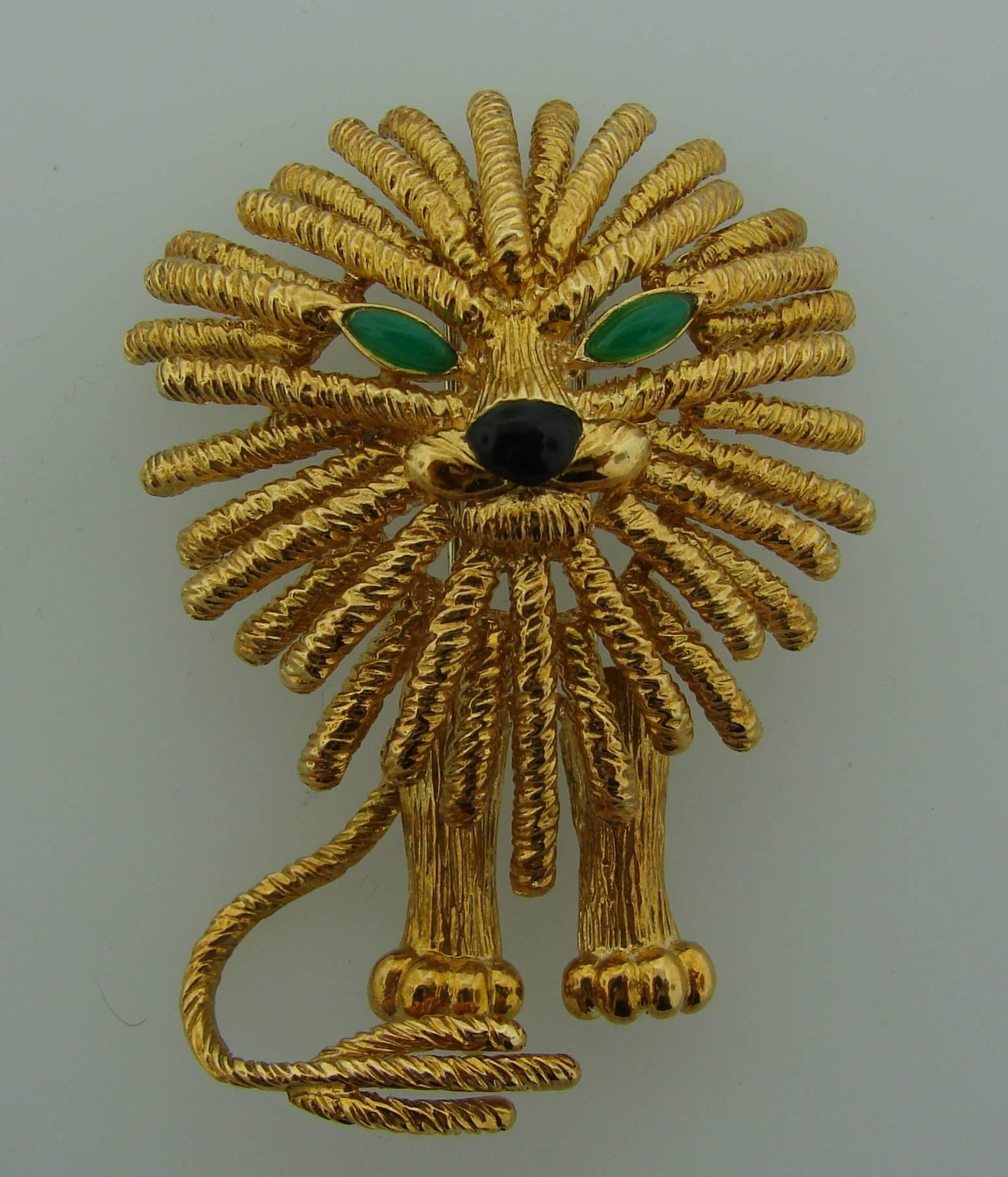 Cute and well-known Lion clip created by Van Cleef & Arpels in France in the 1970's. Made of 18k yellow gold, Lion's eye accented with chrysoprase and nose with black onyx. 
The clip measures 2-3/8