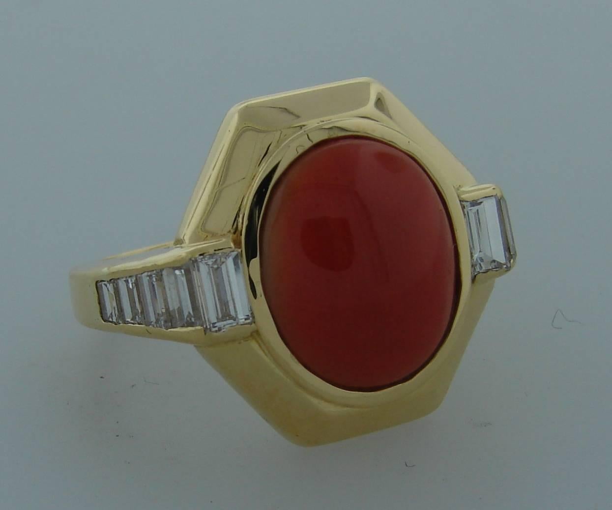 Elegant cocktail ring created by Bulgari in Italy in the 1980's. Features a beautiful oval Mediterranean coral framed in 18k yellow gold setting and accented with diamonds. The diamonds are baguette and emerald cut, G color, VS1 clarity, total