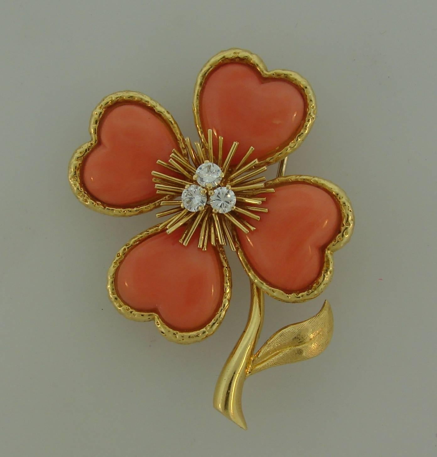 Signature Clover clip created by Van Cleef & Arpels in France in 1950's that would be a great addition to your jewelry collection. 
It is made of 18 karat (stamped) yellow gold, Mediterranean coral and accented with three round brilliant cut