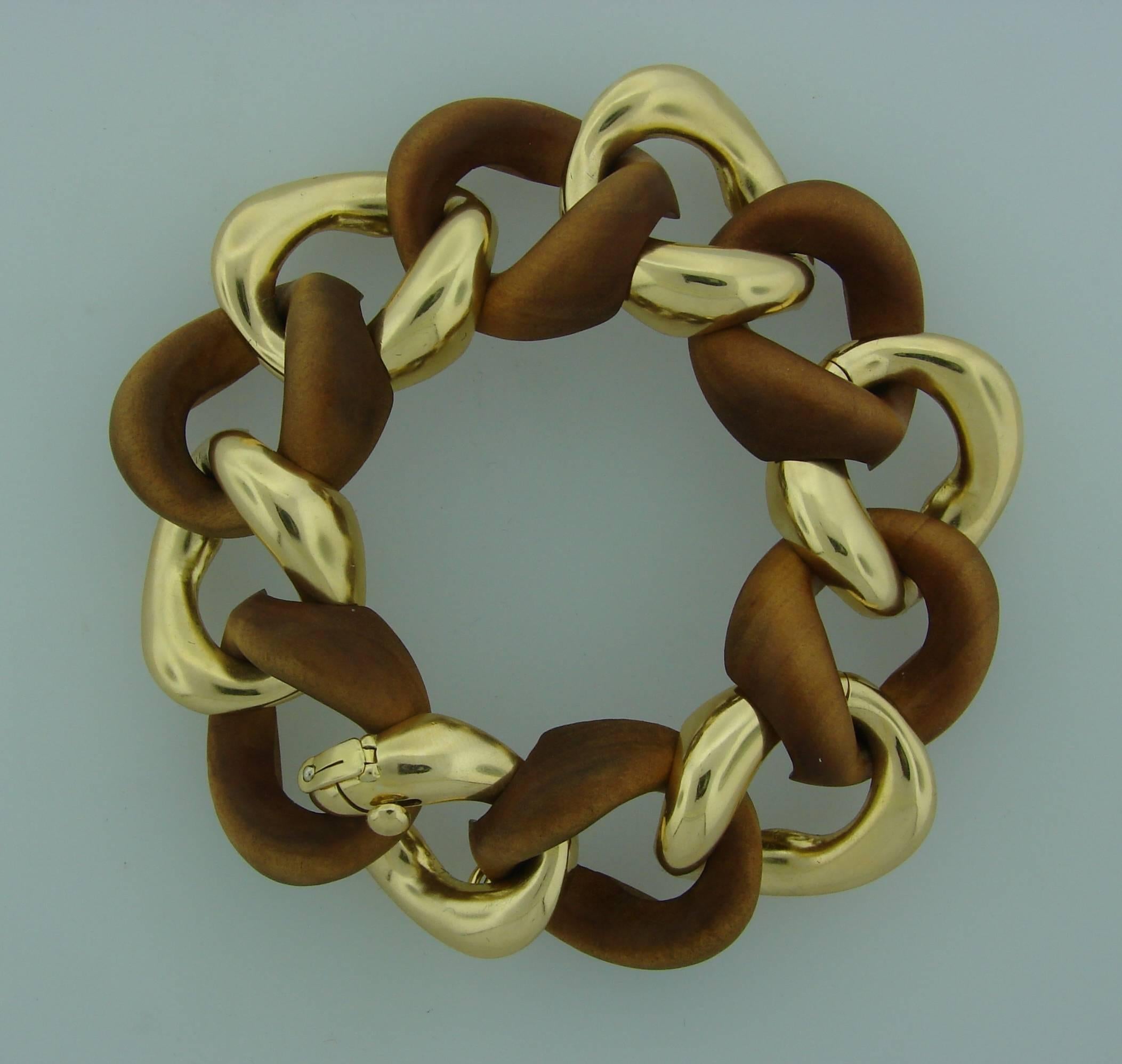 Signature Seaman Schepps link bracelet. Chic and wearable, the bracelet will make a great addition to your jewelry collection. It is made of carved wood and 18 karat (stamped) yellow gold. 
The bracelet is1