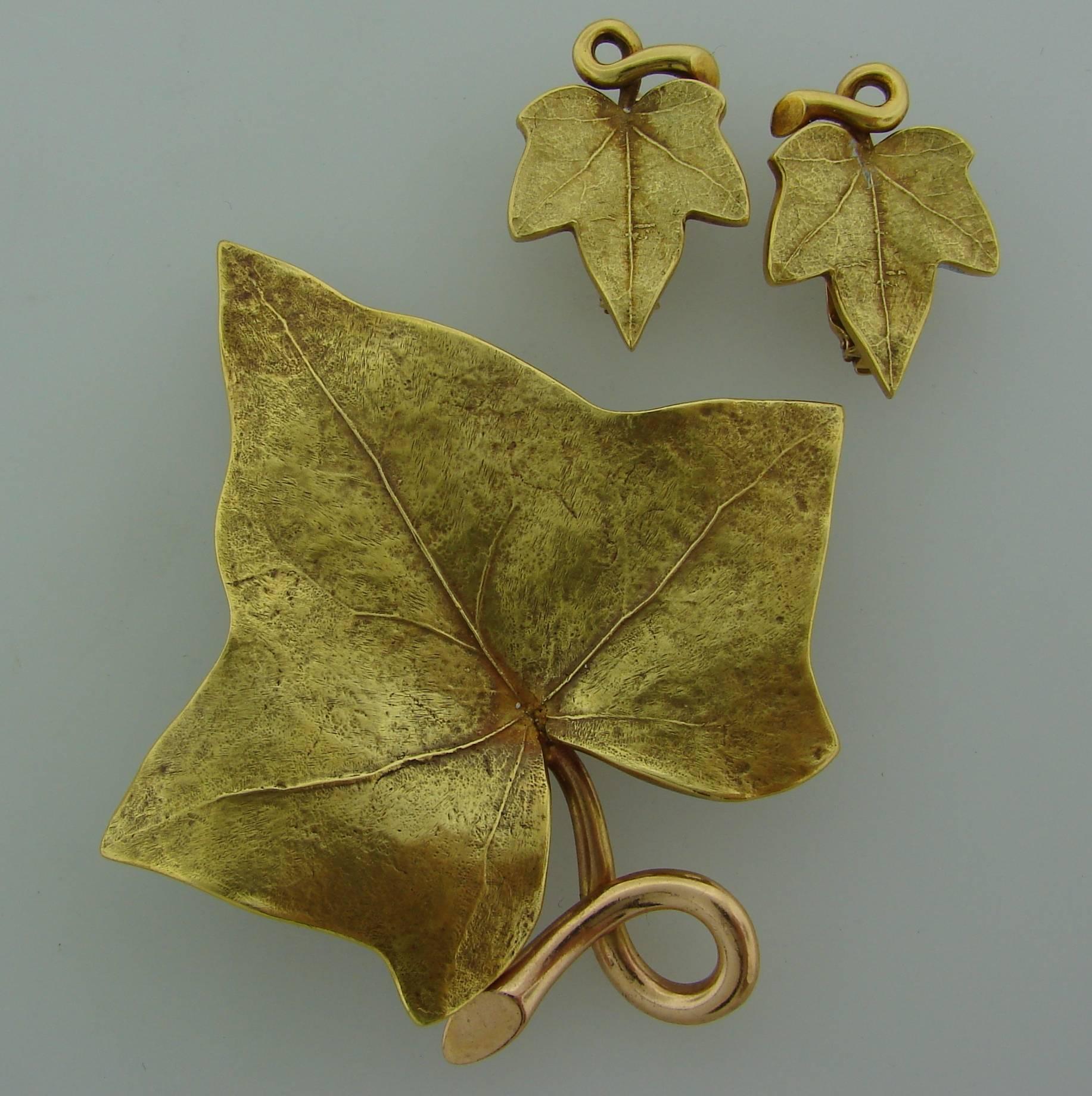 French chic Grape Leaf set consisting of a clip and a pair of earrings was created by Cartier in the 1950's. It makes a tasteful accent to any outfit. 
The pin is made of 14 karat (stamped) yellow gold. The earrings are made of 14 karat (tested)
