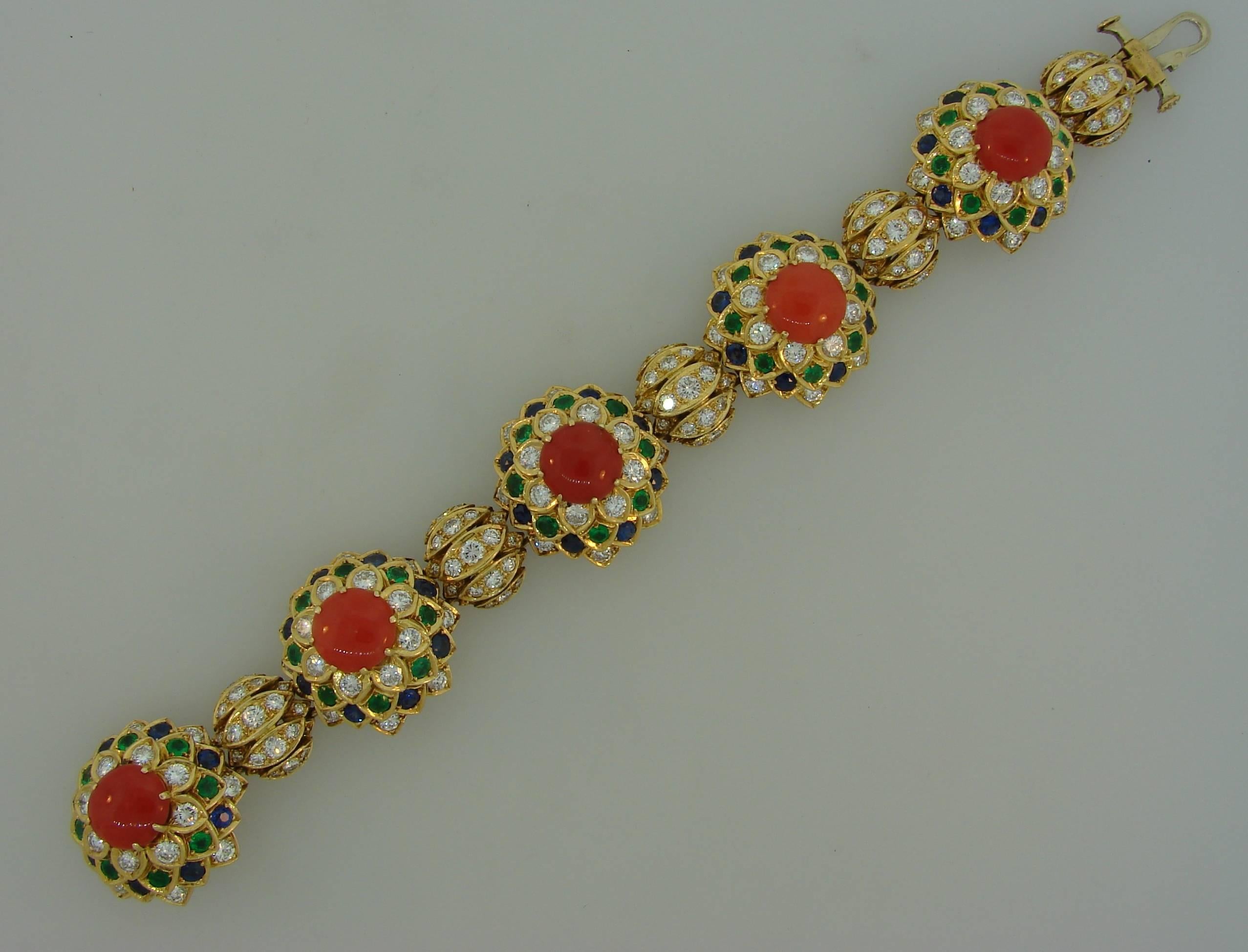 Chic colorful bracelet created by Cartier in the 1950's. Rare. Its design was inspired by Louis Cartier travels to Russia Features five coral cabochons set in 18 karat yellow gold and accented with diamonds, sapphires and emeralds. Approximate total