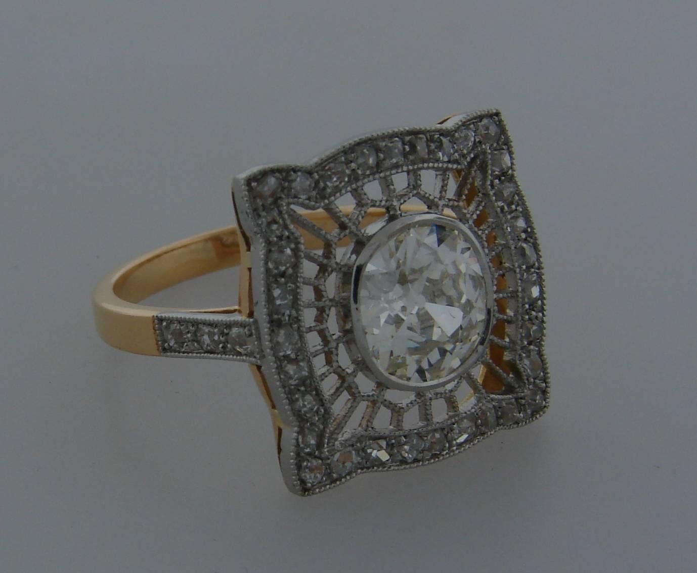 Delicate and elegant ring created in the 1960's as an Edwardian Revival piece. 
The top is made of platinum (tested) and set with old mine cut diamonds, the bottom and the shank are made of 18 karat (tested and stamped) rose gold. 
The center