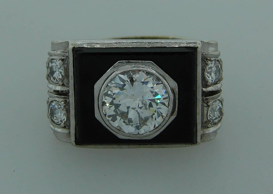 Elegant and dramatic Art Deco ring created in France in the 1930s.  Features an approximately 1.07 carat Old European cut diamond set in platinum and framed in black onyx. The sides of the ring are accented with Old European cut diamonds totaling