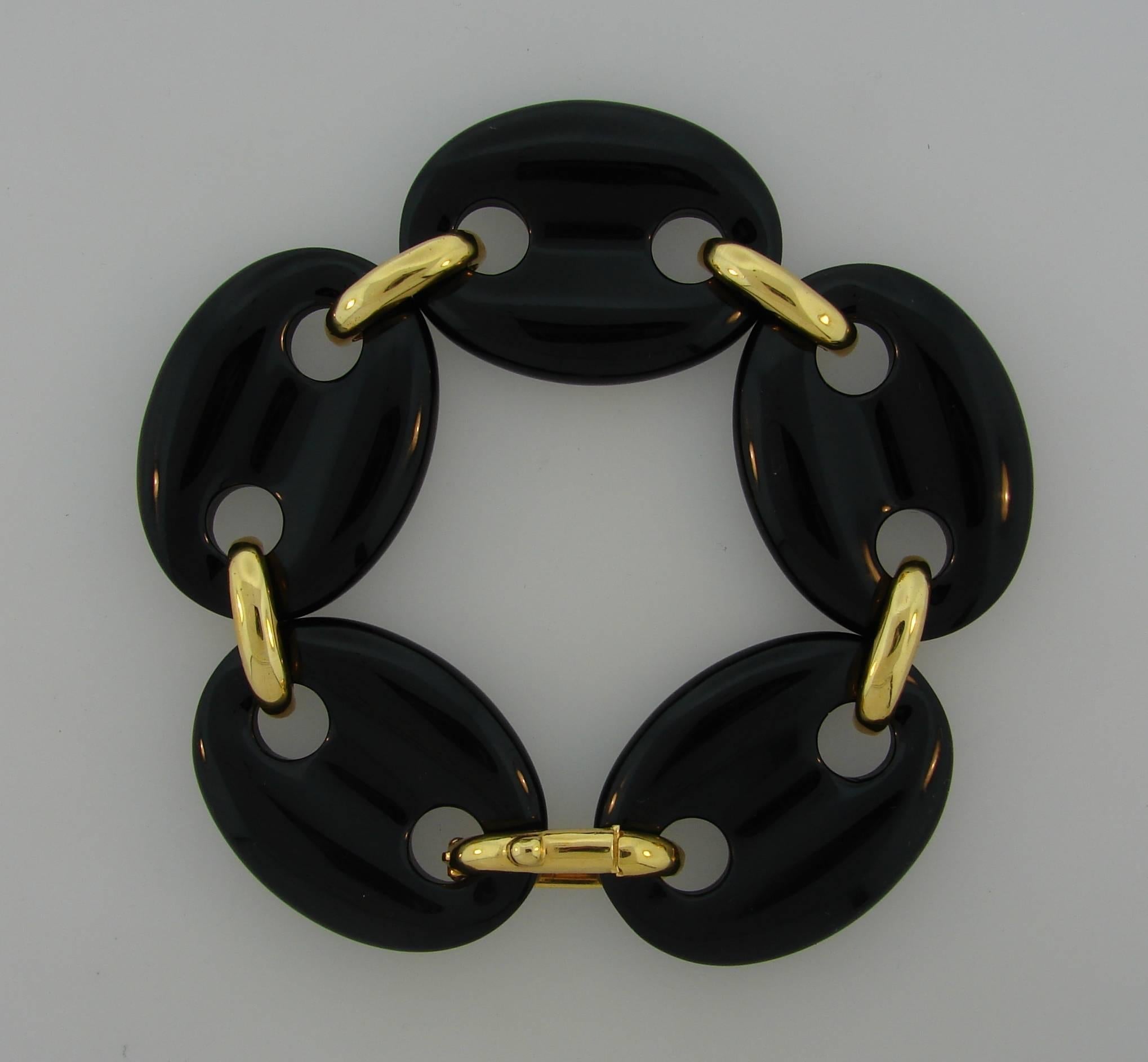 Bold and articulated bracelet created by Aldo Cipullo in the 1970s. Features five large oval carved black onyx links connected with 18 karat yellow gold links. 
The bracelet makes a statement, is wearable and is a great addition to your jewelry