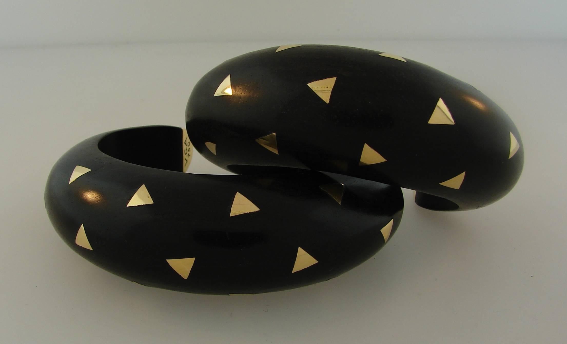 Chic and unusual pair of bangle bracelets created by Van Cleef & Arpels in France in the 1970's. The bangles are made of ebony wood and 18 karat (stamped) yellow gold. Elegant warmth of the ebony wood is accentuated with yellow gold sparkles.